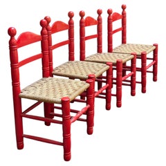 Lot de quatre chaises à dossier en échelle avec assise en jonc peintes en rouge