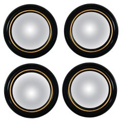Juego de cuatro espejos convexos de ojo de buey Regency en yeso negro y pan de oro
