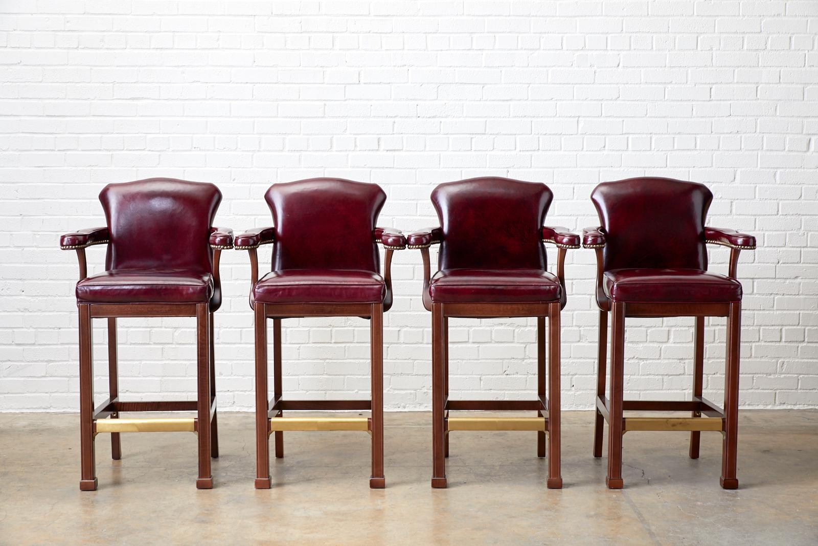 Grand set of four mahogany bar or kitchen counter stools featuring a cordovan leather hide upholstery. Bespoke set of American chairs from Hickory, North Carolina constructed with wide serpentine arms and a shaped back crest in the English Regency