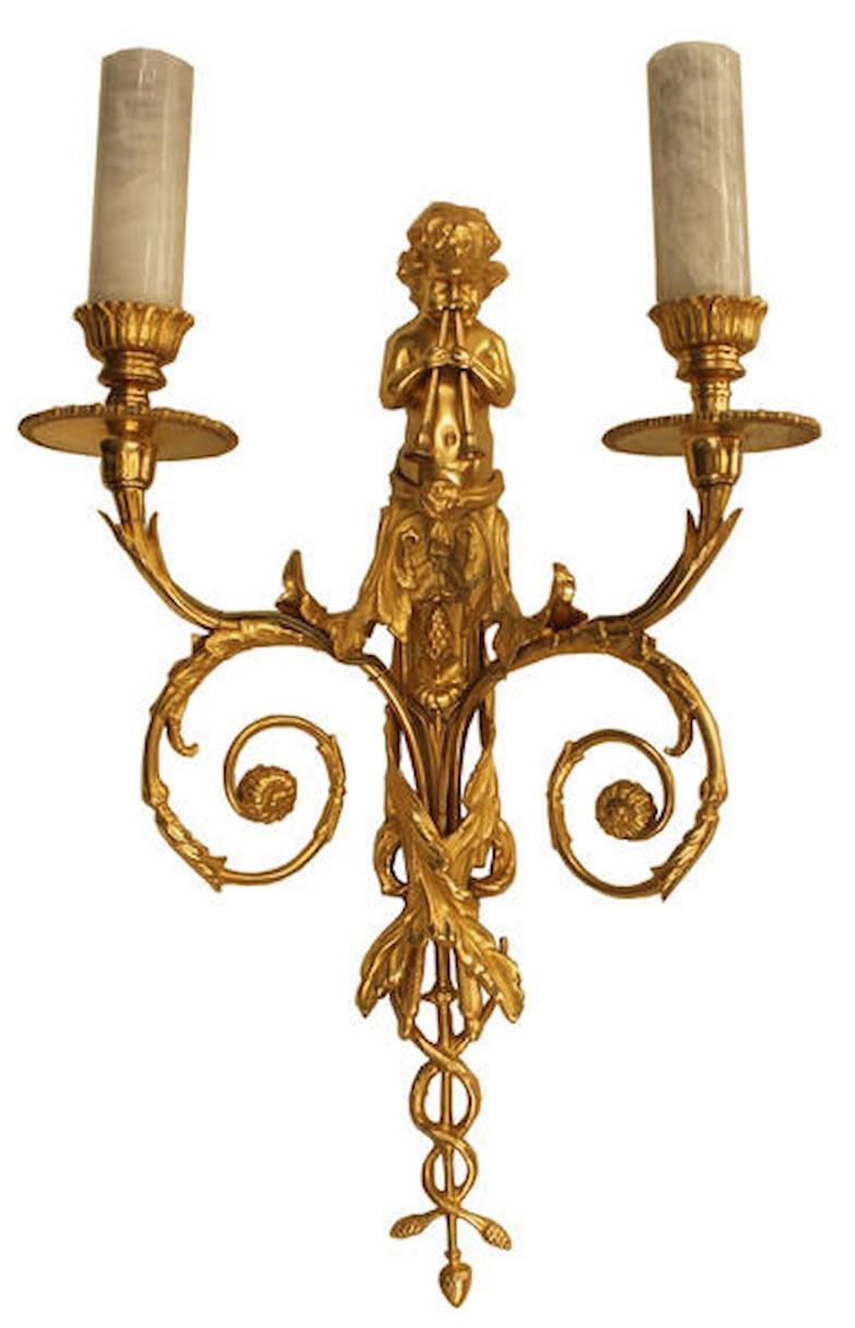 Un ensemble de  Appliques murales à deux bras en bronze doré ou ormolu, chérubin en cristal de roche. Circa 1880s. 
Remise à neuf pour répondre aux spécifications électriques modernes.
Les deux bras comportent chacun des tubes de bougie en cristal