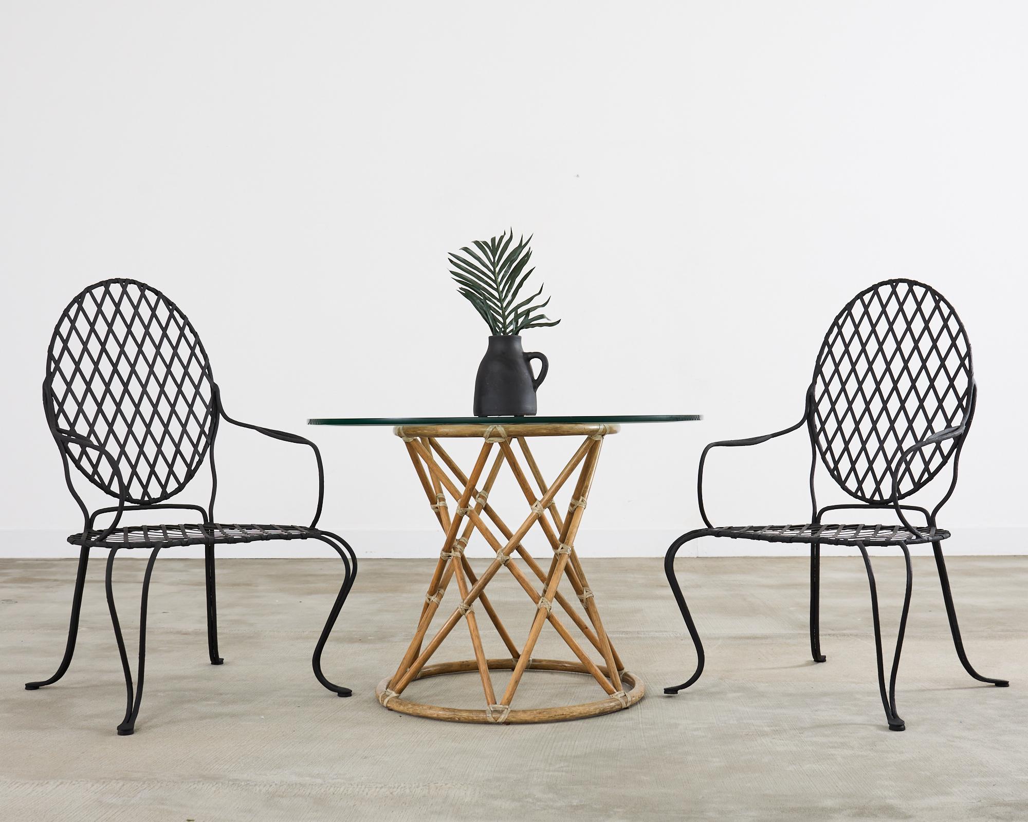 Precioso juego de cuatro sillones de comedor de hierro para patio y jardín atribuido a Rose Tarlow Melrose House Los Ángeles, CA. El conjunto presenta un gran marco de hierro con motivo de ramitas de imitación de bois con inserción de celosía