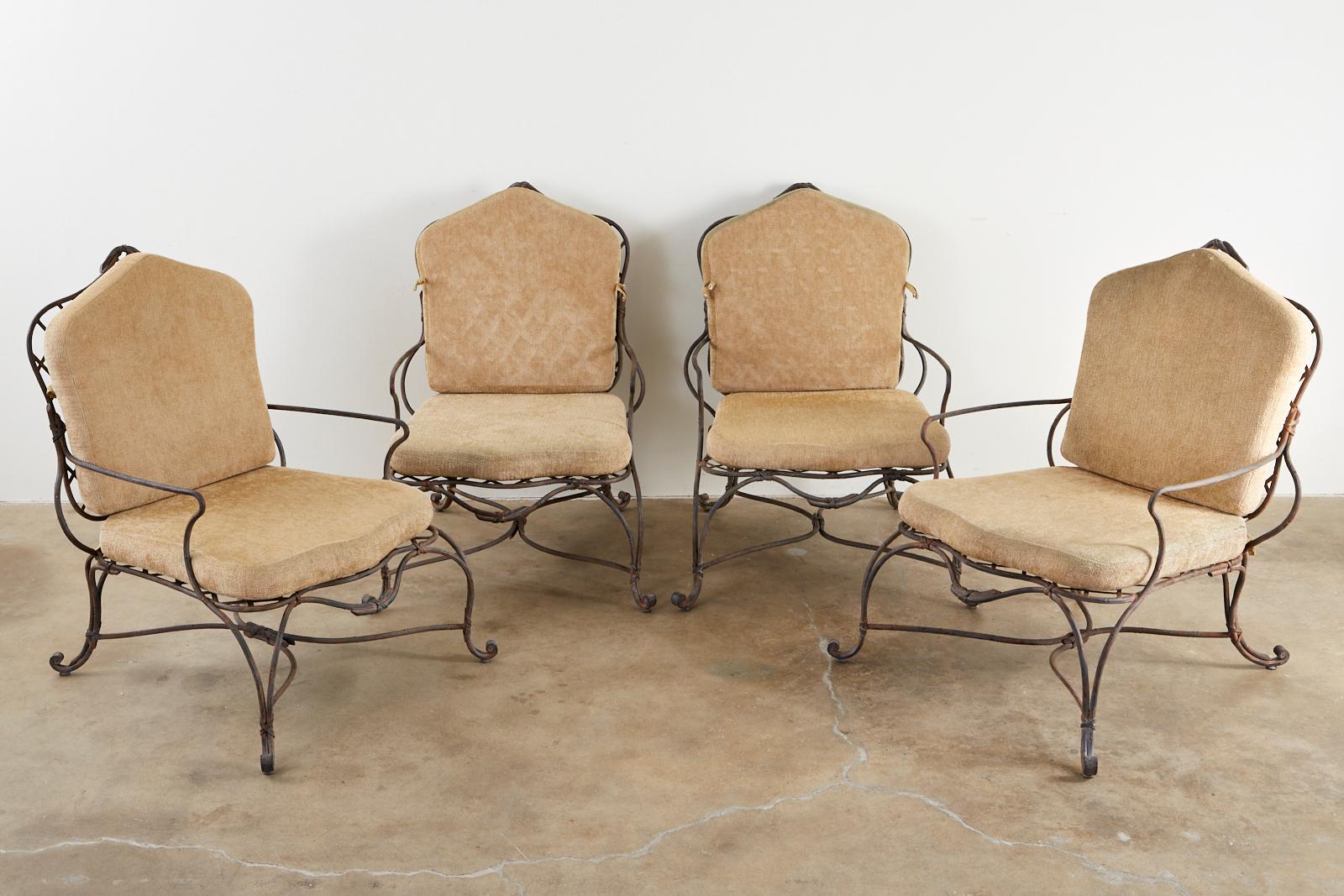 Amazing set of four iron faux bois twig garden lounge chairs by Rose Tarlow Melrose House. Large, substantial frames featuring a delicate faux-bois twig design with ribbon bows. The seat and back have a geometrical lattice inset and the iron has a