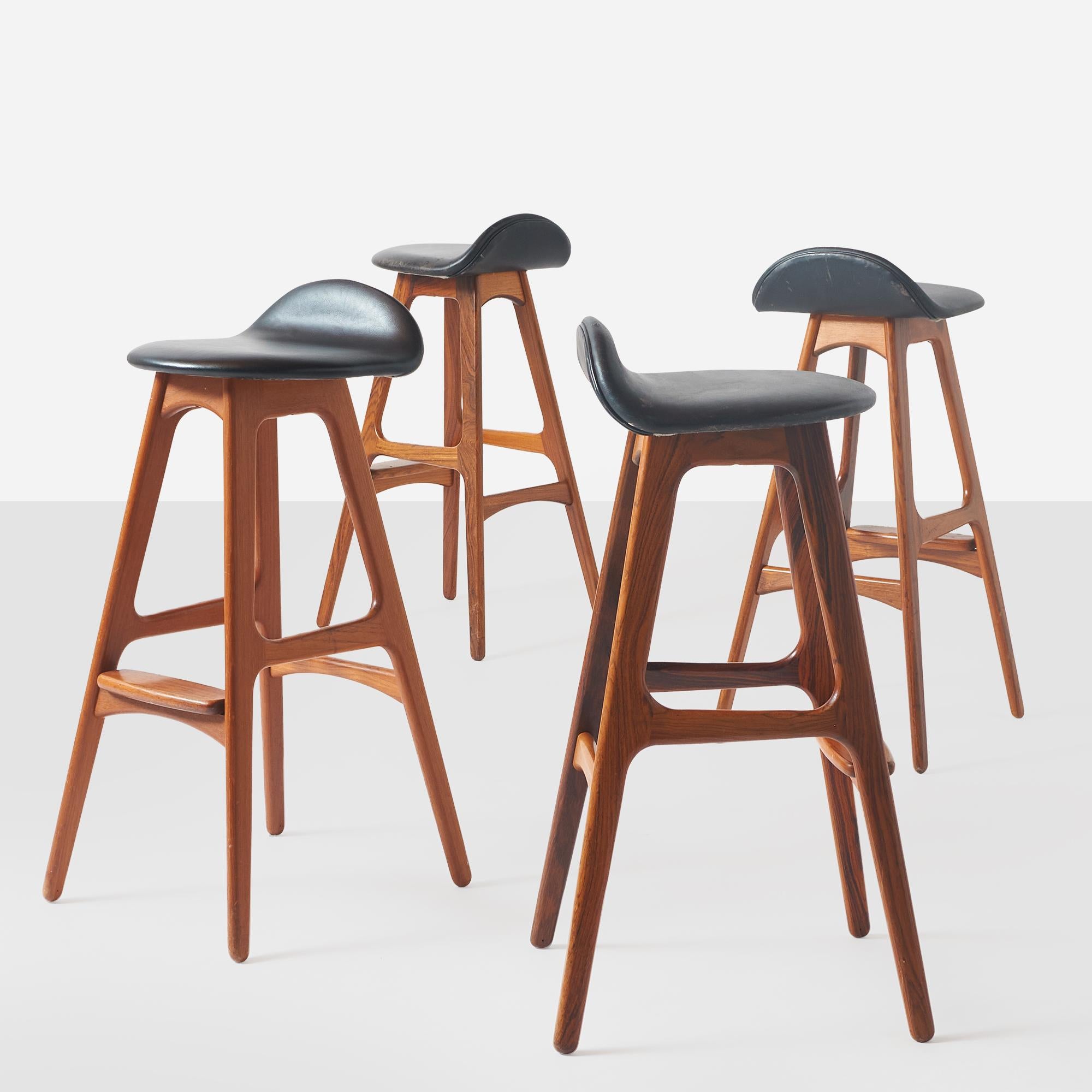 A set of 4 teak frame barstools designed by Erik Buch and produced by O.D. Mobler in Denmark. Each stool has black leather seat and a rosewood footrest. Retains manufacturers label.