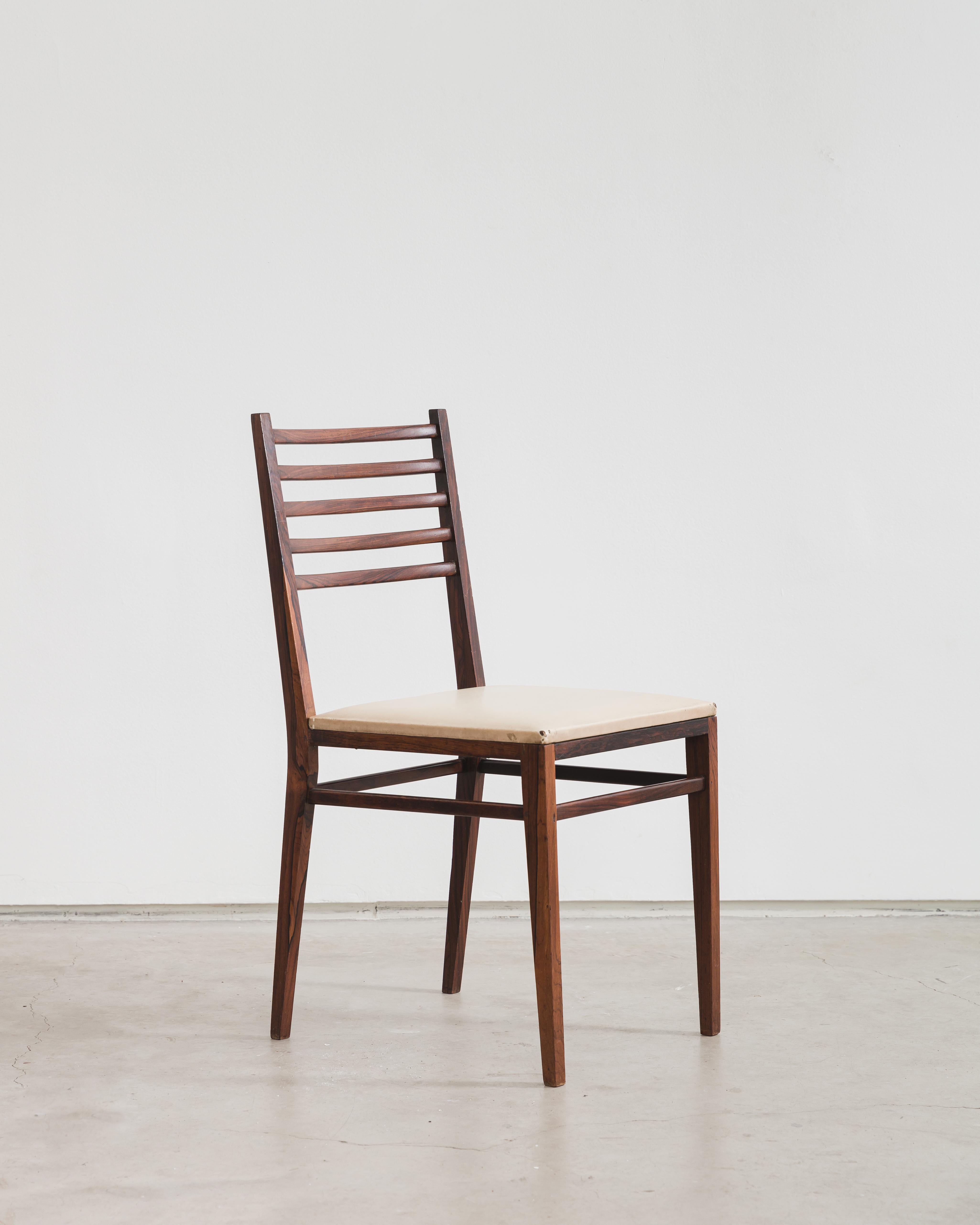 This chair designed by Geraldo de Barros has a light structure in solid rosewood, a characteristic of Unilabor's production, which used fine shapes in its designs for better use of its materials. The backrest is formed by five horizontal rods, with