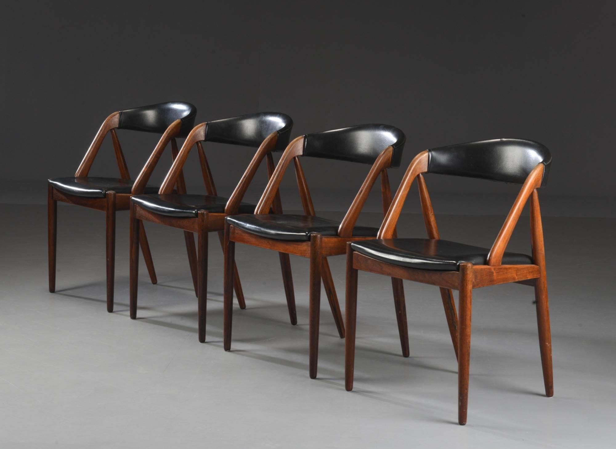 Set of four rosewood dining chairs by Kai Kristiansen, 1960. Rosewood chairs with tapered legs upholstered in black leather.