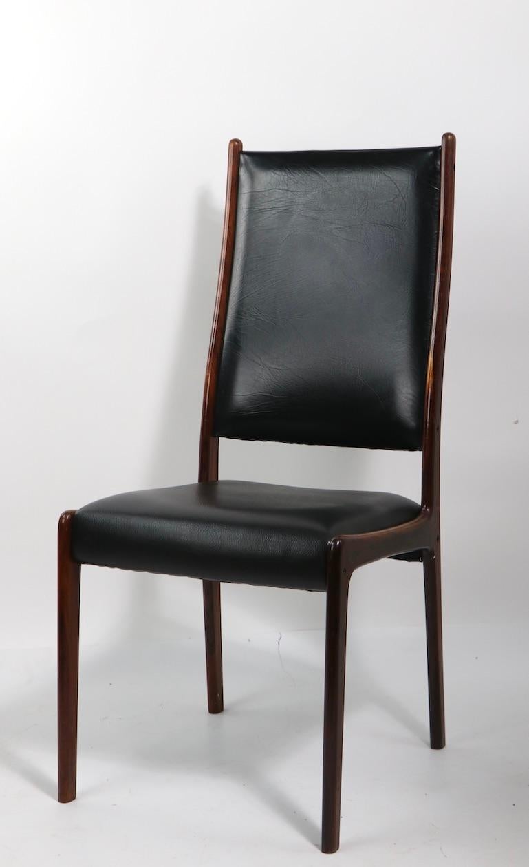 Unusual high back rosewood frame dining chairs designed by Johannes Andersen for Mogens Kold, Denmark.. All 4 chairs are structurally sound, and sturdy and the wood is in great, original condition, they will need to be reupholstered. Sexy,