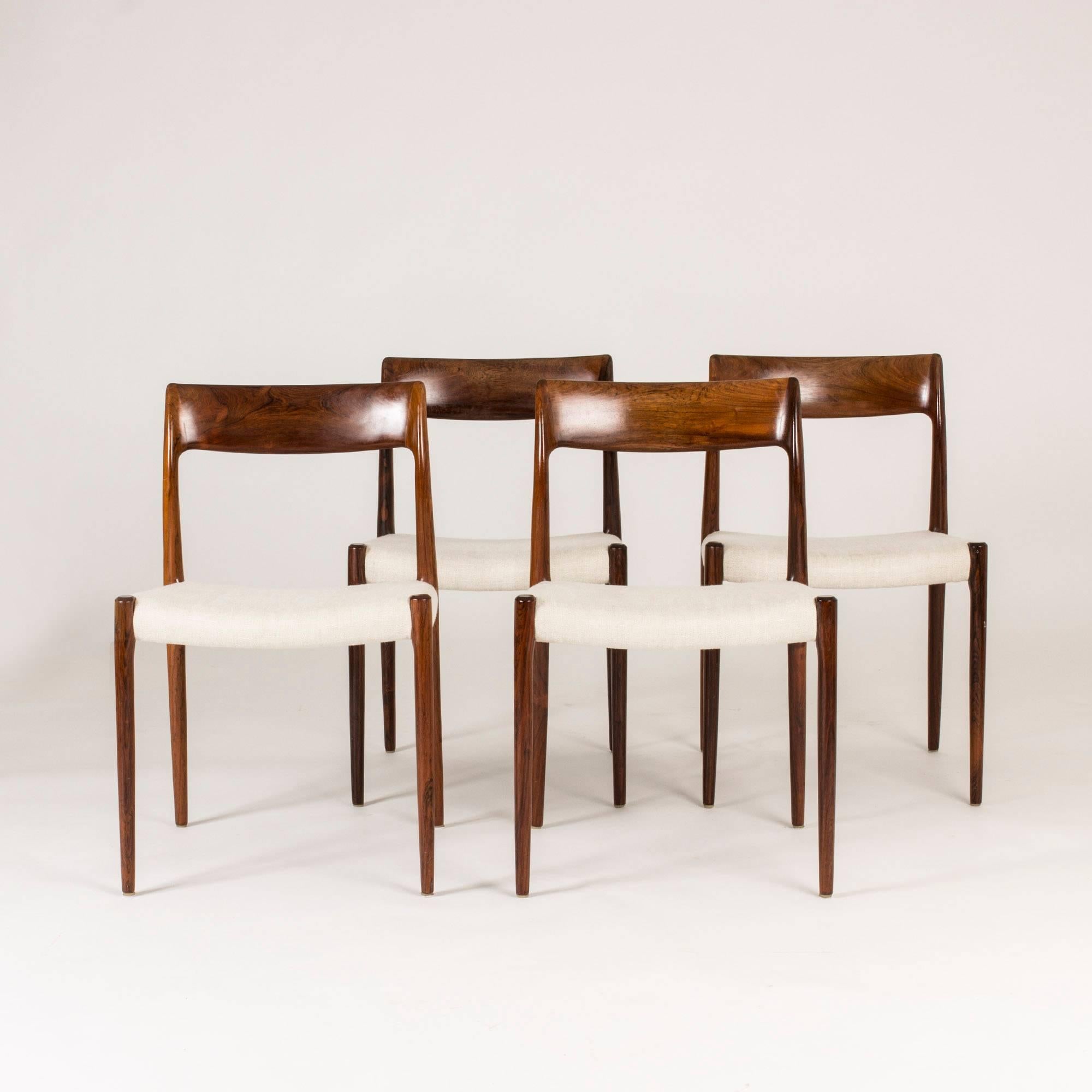 Set of four rosewood dining chairs by Niels O. Møller in an elegant simplistic design. Dark, glossy rosewood accentuated by the off-white wool seats.