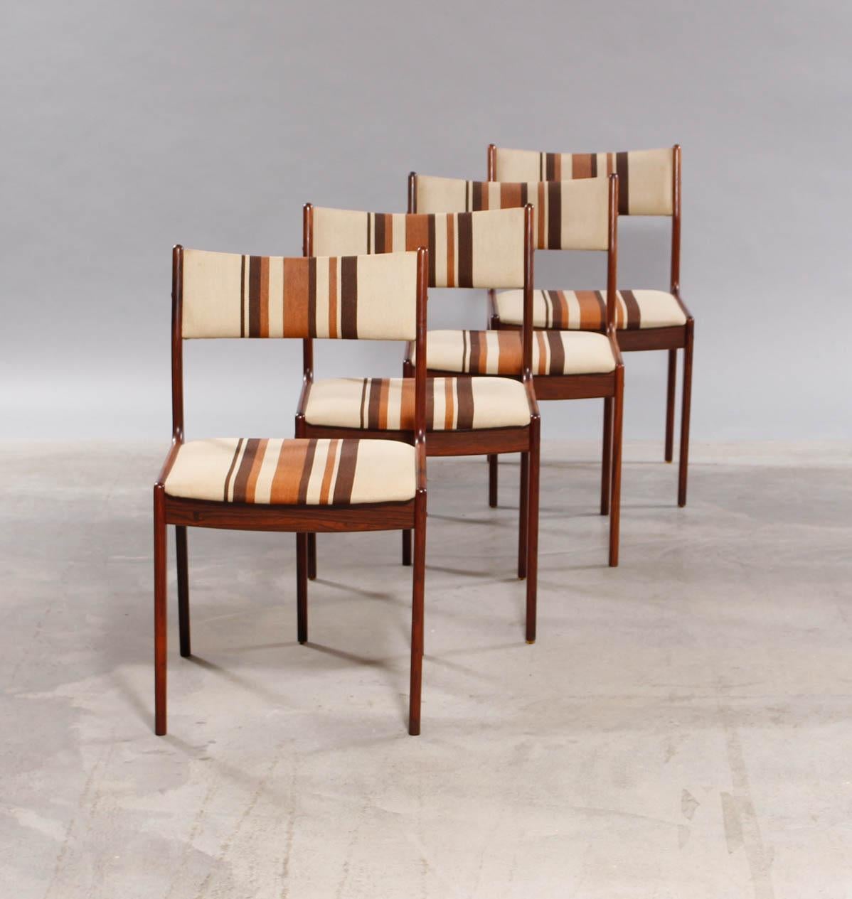 Set of four dining chairs in rosewood by Danish furniture manufacturer. Back and seat upholstered with striped fabric.