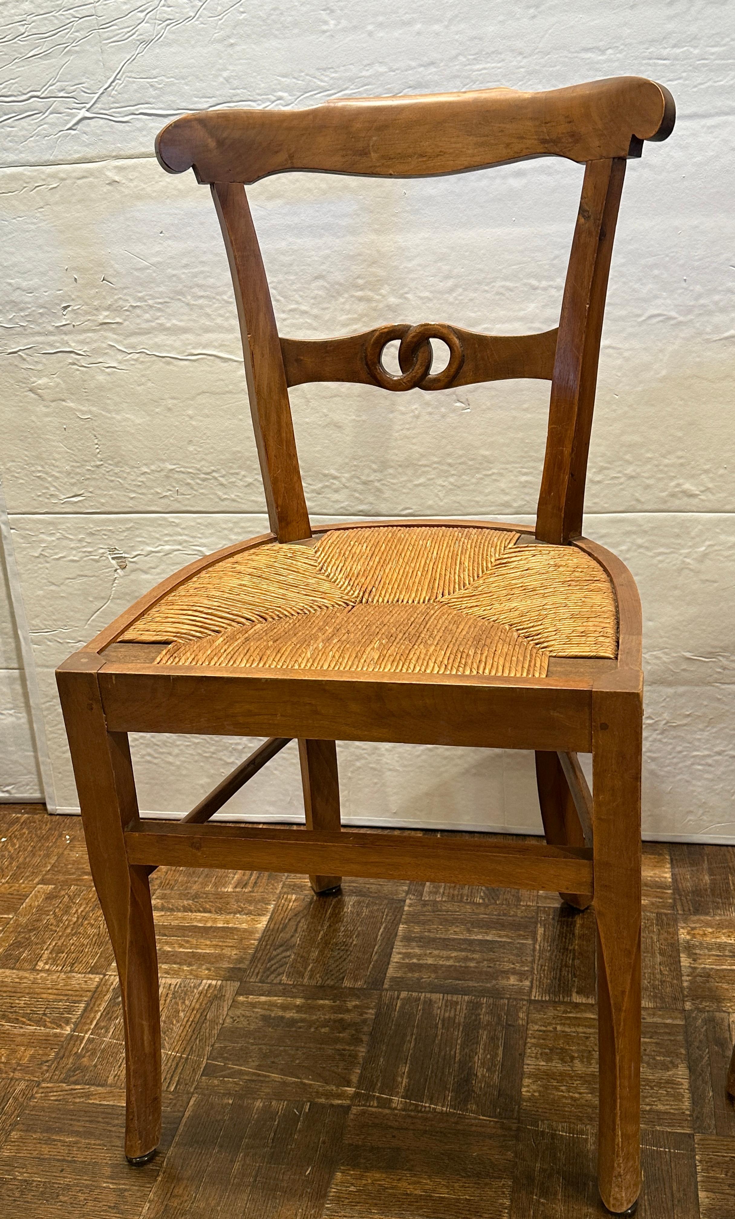 Set of four very sturdy country French rush seat chairs.  Chair backs are beautifully carved double rings.  Legs are soft cabrioles in hard stain wood.
 Rush seats are in great condition.