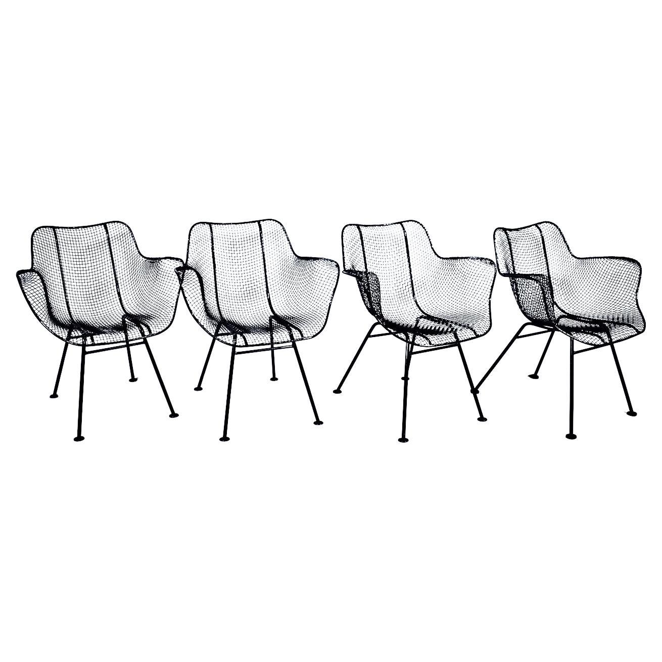 Originaler Satz von 4 Russell Woodard Black Iron & expanded Wire Armchairs. Das schmiedeeiserne Gestell mit ergonomisch geformtem Sitz und Rückenlehne aus schwarzem Drahtgeflecht ist mit flachen Füßen ausgestattet. Innen-/Außenplätze. Klassisch.