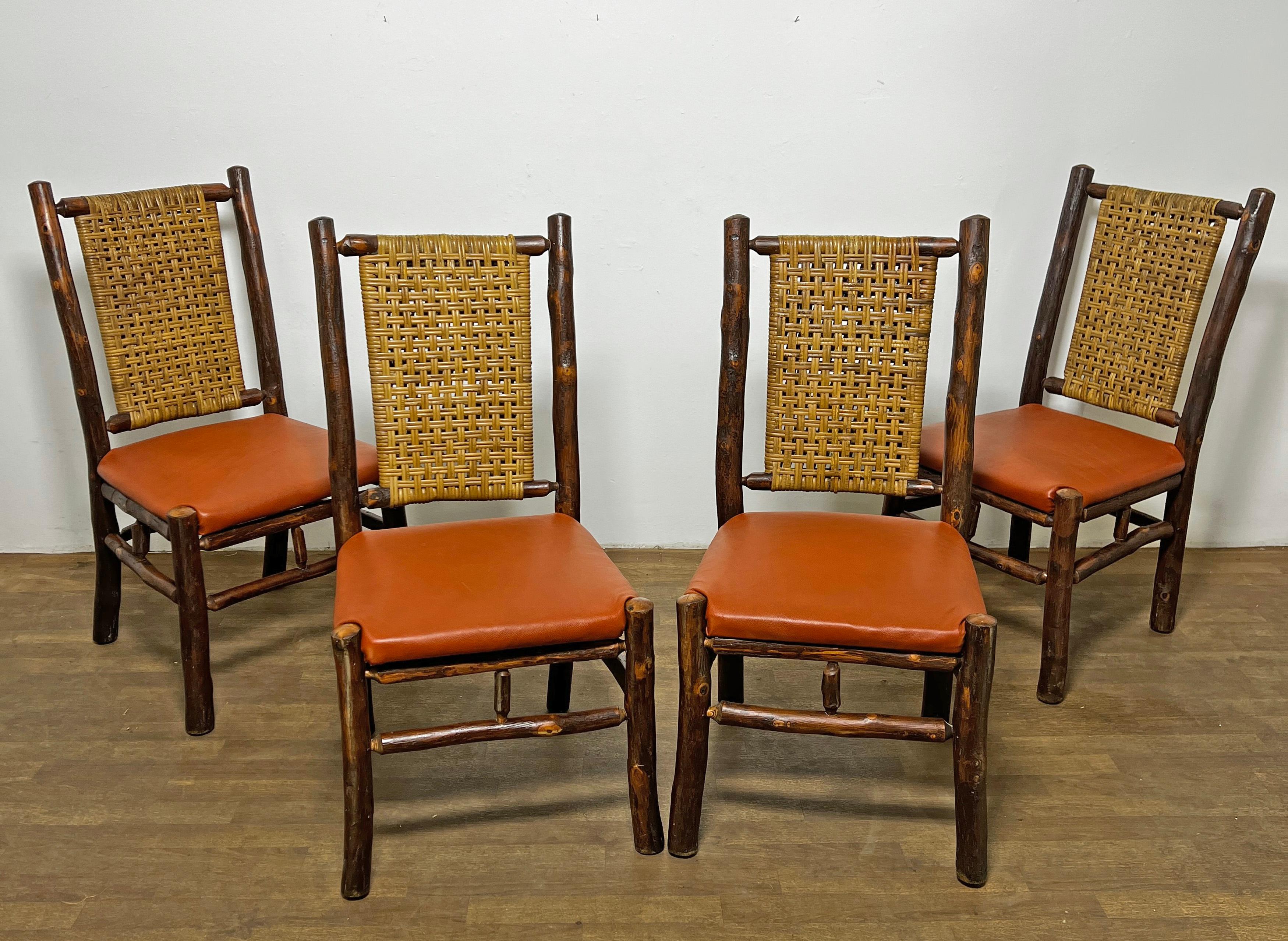 Un set di quattro sedie lodge vintage realizzate in pali di hickory rustico con schienali a canne e sedili in vera pelle conciata a sella. Questo intramontabile stile Adirondack, reso popolare dalla Old Hickory Furniture Co. dell'Indiana all'inizio