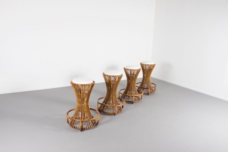 Set of four rare bar stools in very good condition.

Designed by Tito Agnoli in the 1950s 

Manufactured by Bonacina, Italy 

These high quality stools were handcrafted with natural materials.

The Rattan base has an elegant form which elegantly