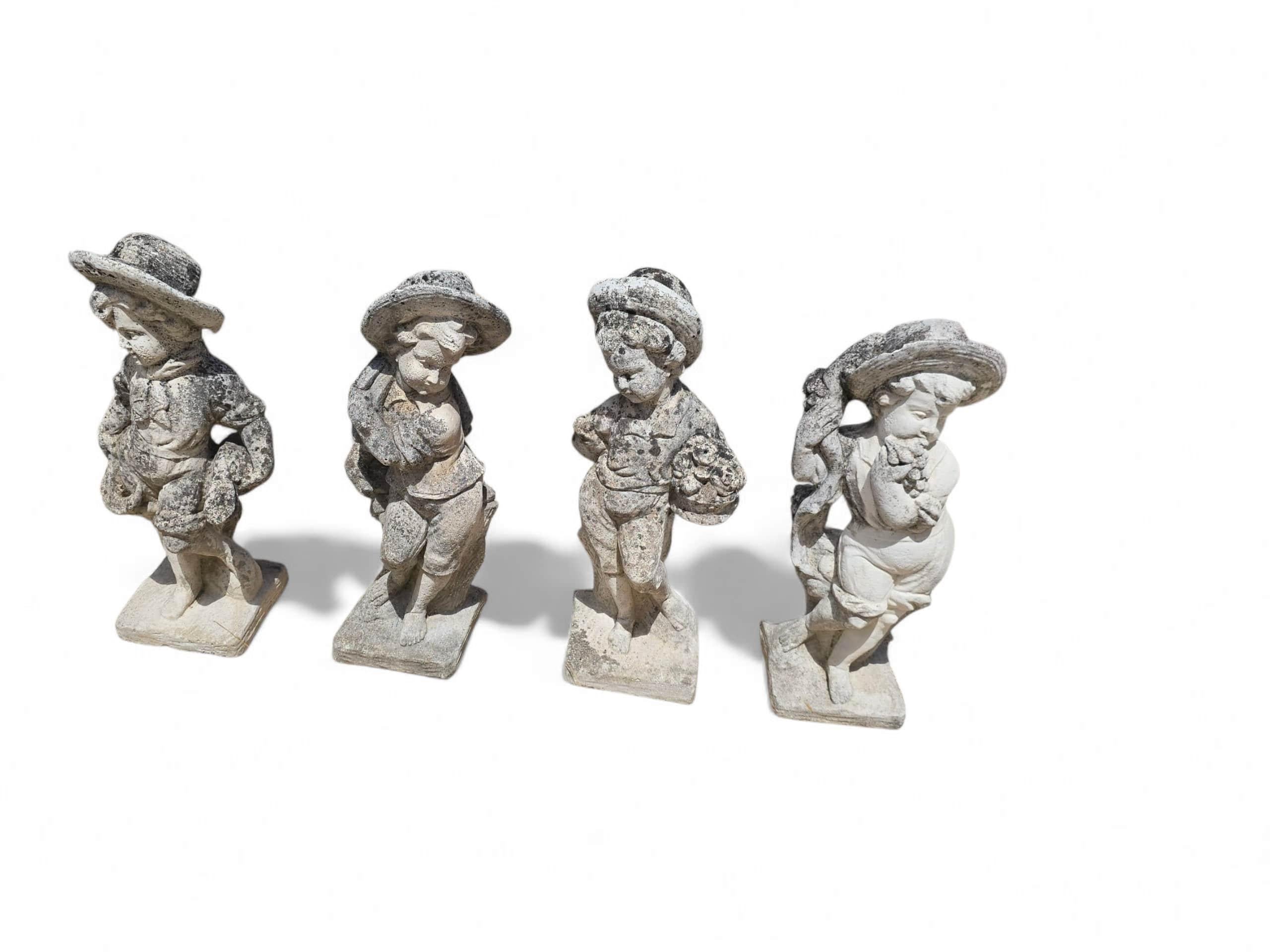 Charming set of four sculptures representing the Four Seasons, hand-crafted in reconstituted stone. Each figure is depicted with symbolic attributes—flowers for Spring, wheat for Summer, grapes for Autumn, and a cloak for Winter—capturing the
