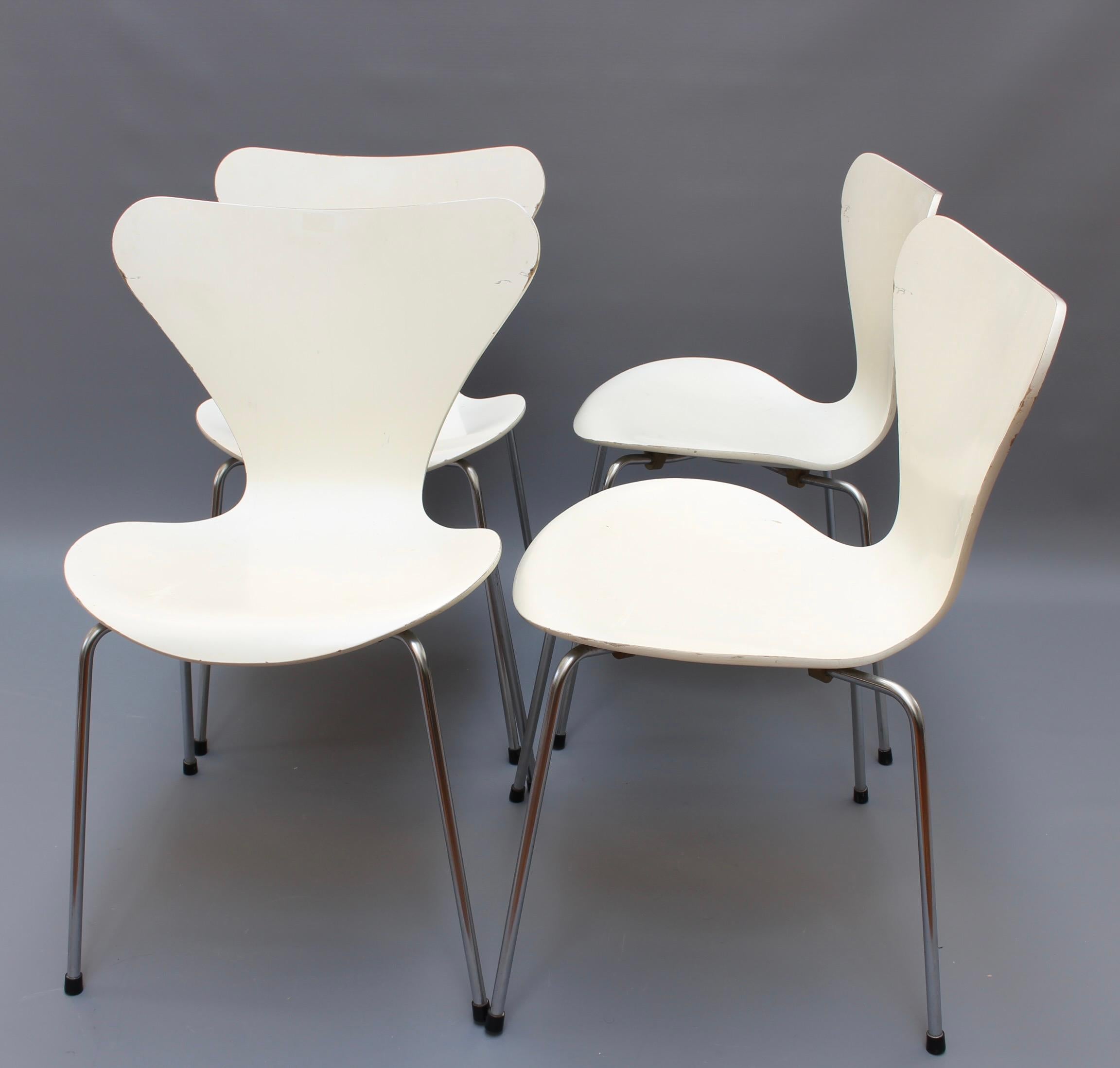 Set of four 'Series 7' stacking white chairs by Arne Jacobsen for Fritz Hansen (1973). Iconic creation by this designer - this set manufactured in 1973 - each with a painted and moulded seat raised on a chromed 'X' frame support. Overall in fair