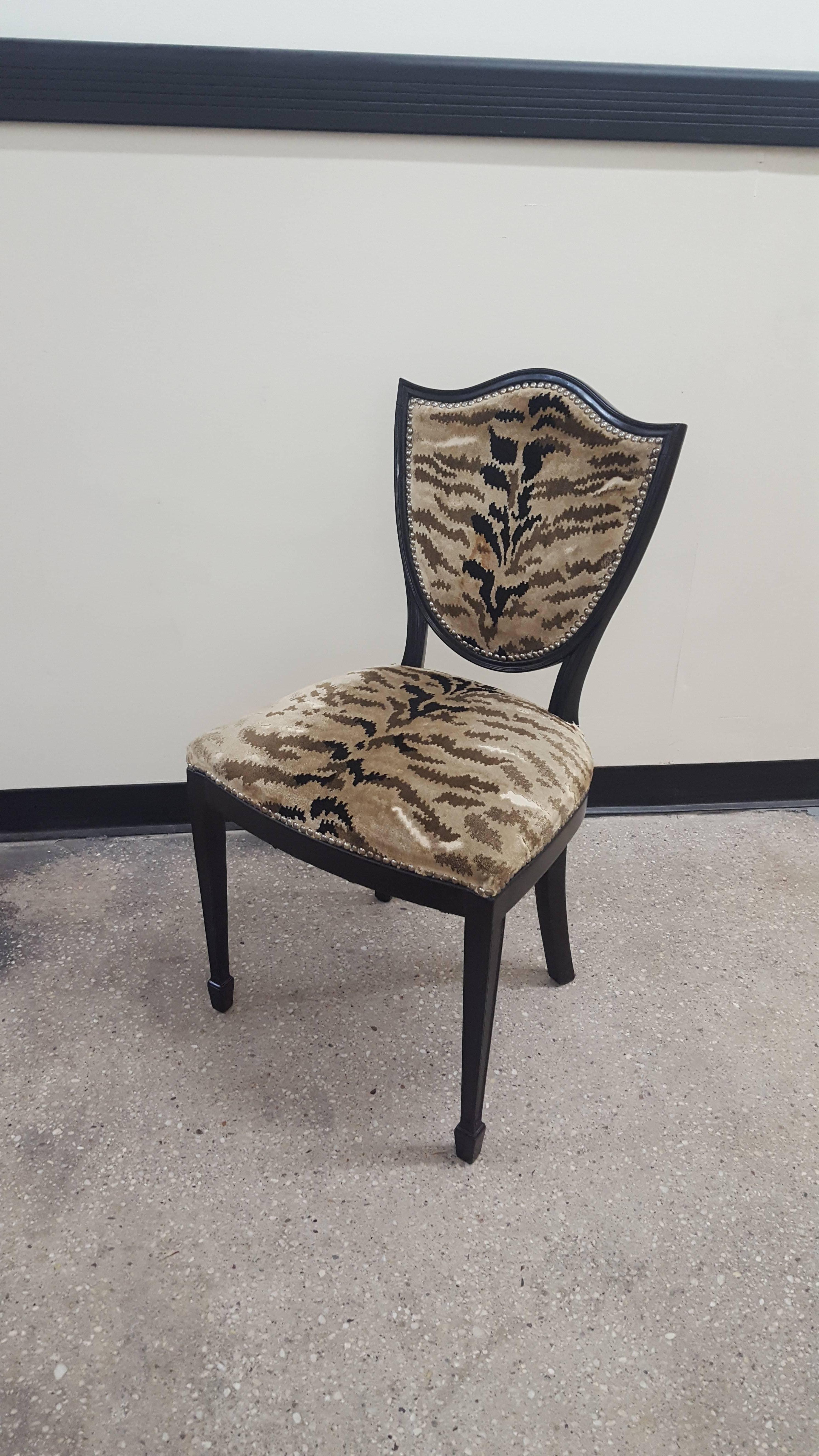 Set of four ebonized shield-back chairs upholstered in animal fabric.