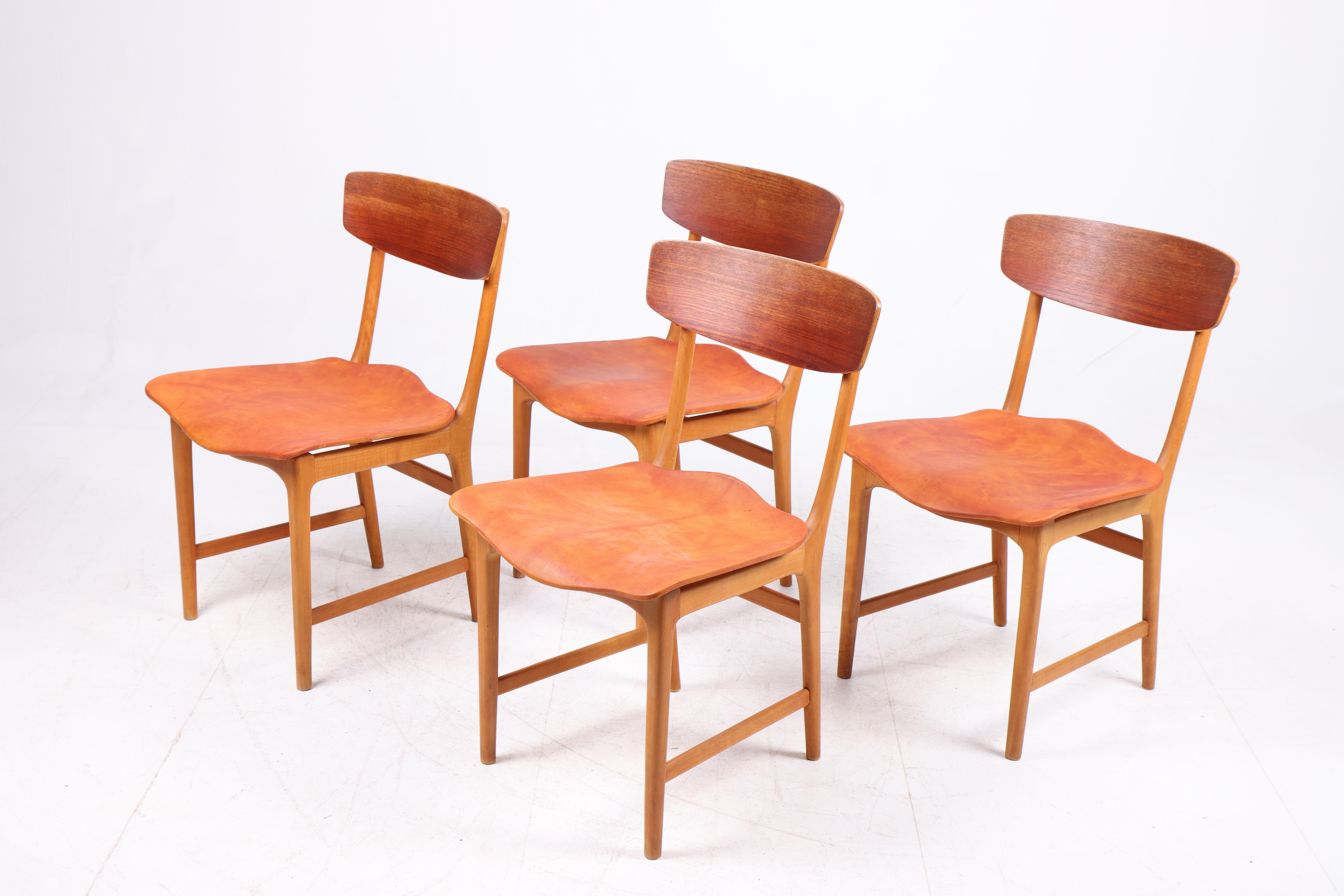 Set of four side chairs in teak and patinated leather. Designed and made in Denmark. Great condition, 1960s.