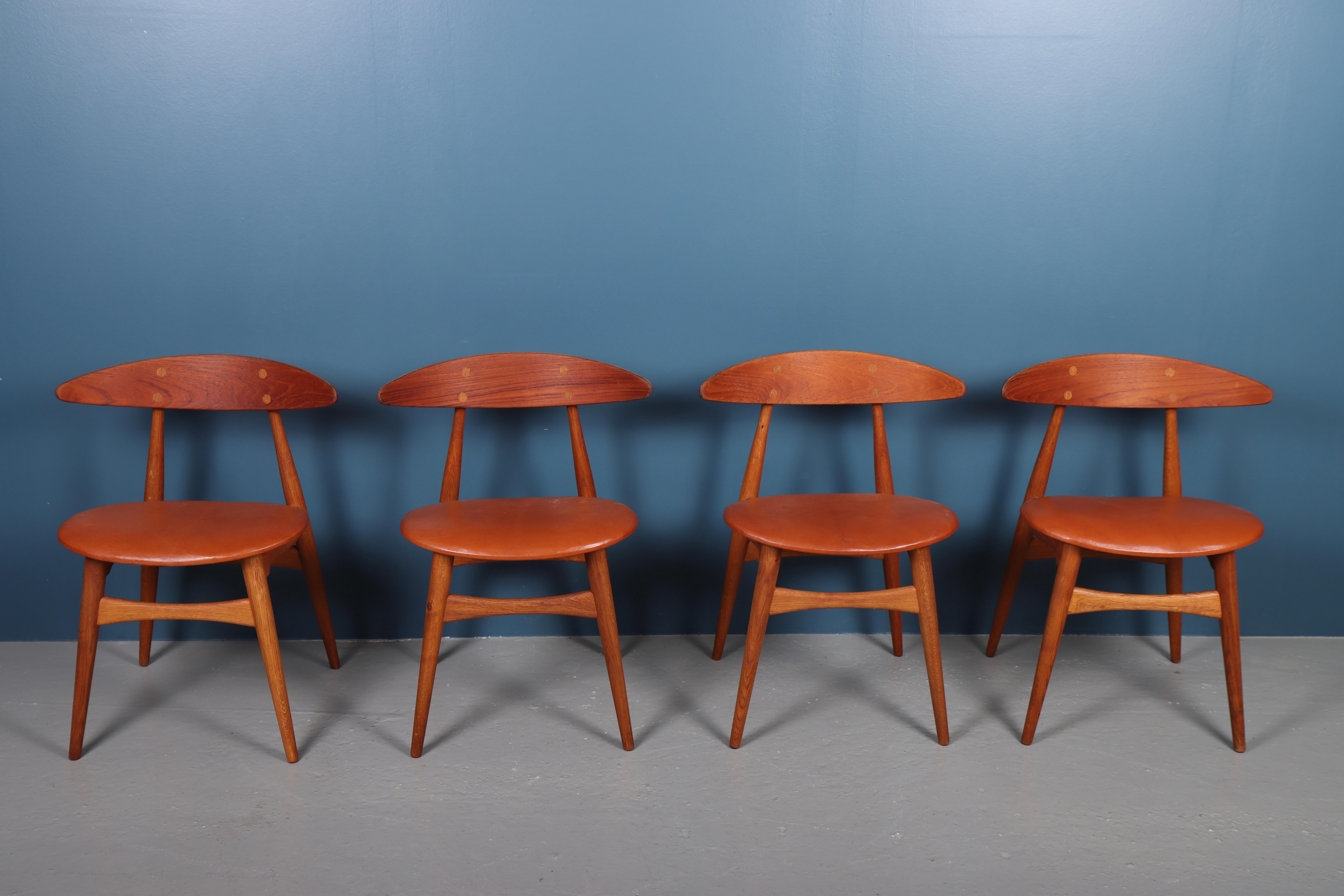Set of four side chairs in teak, oak and patinated leather. Designed by Hans J. Wegner and made by Carl Hansen & Søn in the 1950s. The model name is CH33.