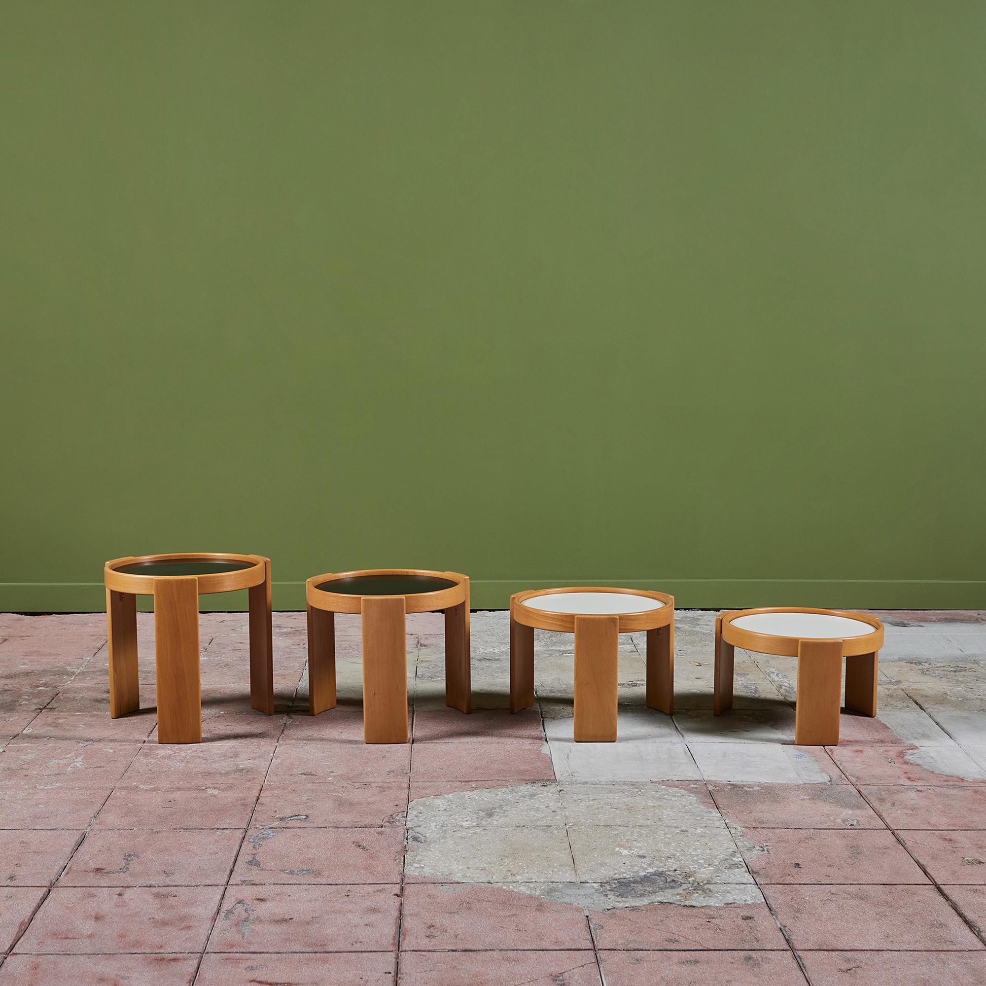 Set of four round side tables by Gianfranco Frattini for Cassina, c.1960's, Italy. The oak tables feature either a black or white laminate top depending on which side you flip upwards. The four tables have varying heights which make them great from