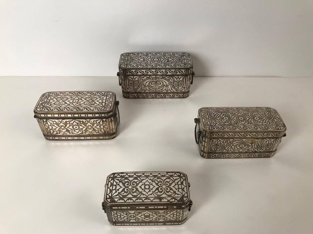 A wonderful collection of four bronze betel nut boxes in various sizes with intricate and quite beautiful inlaid silver designs on all sides. These well made boxes are rectangular with chamfered corners, each with four interior lidded Chambers that