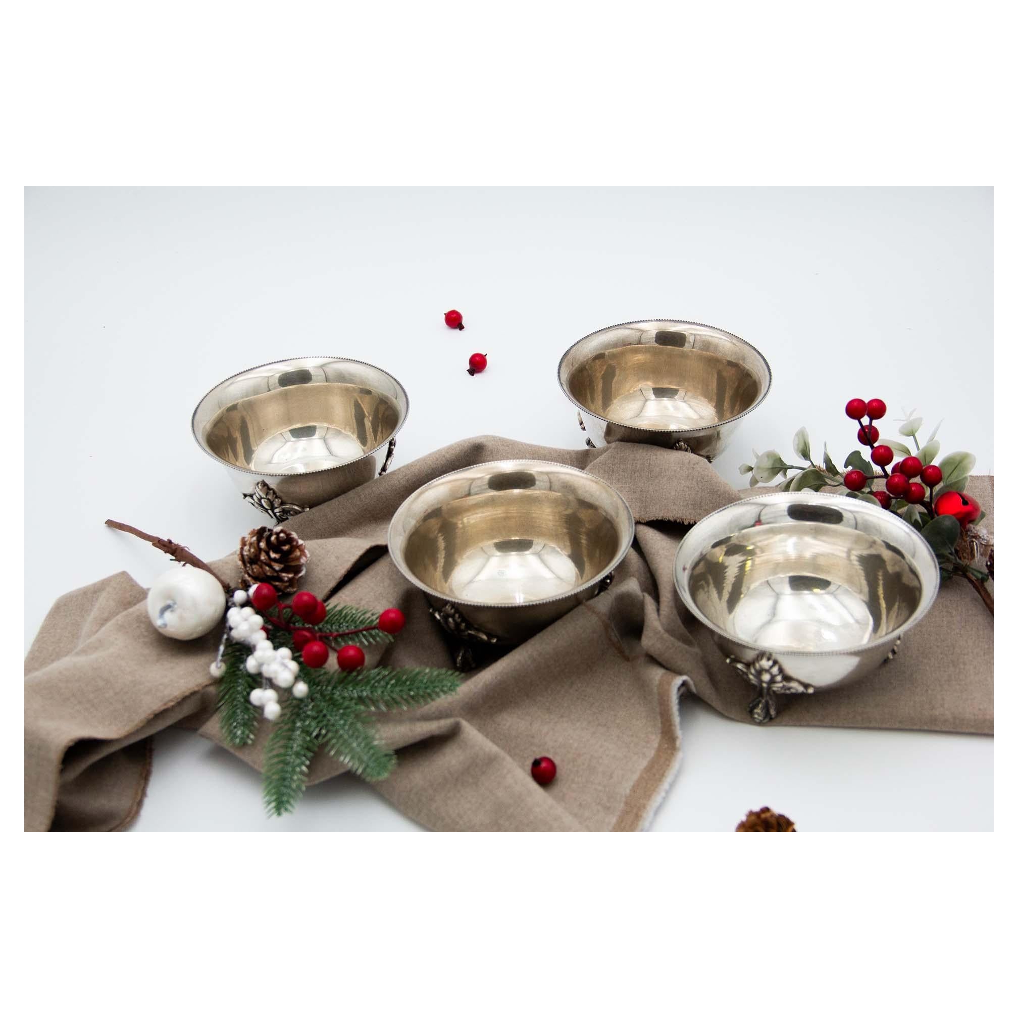 Set of four silver bowls w/ raised claw feet 
reliefs 
friezes on the rim