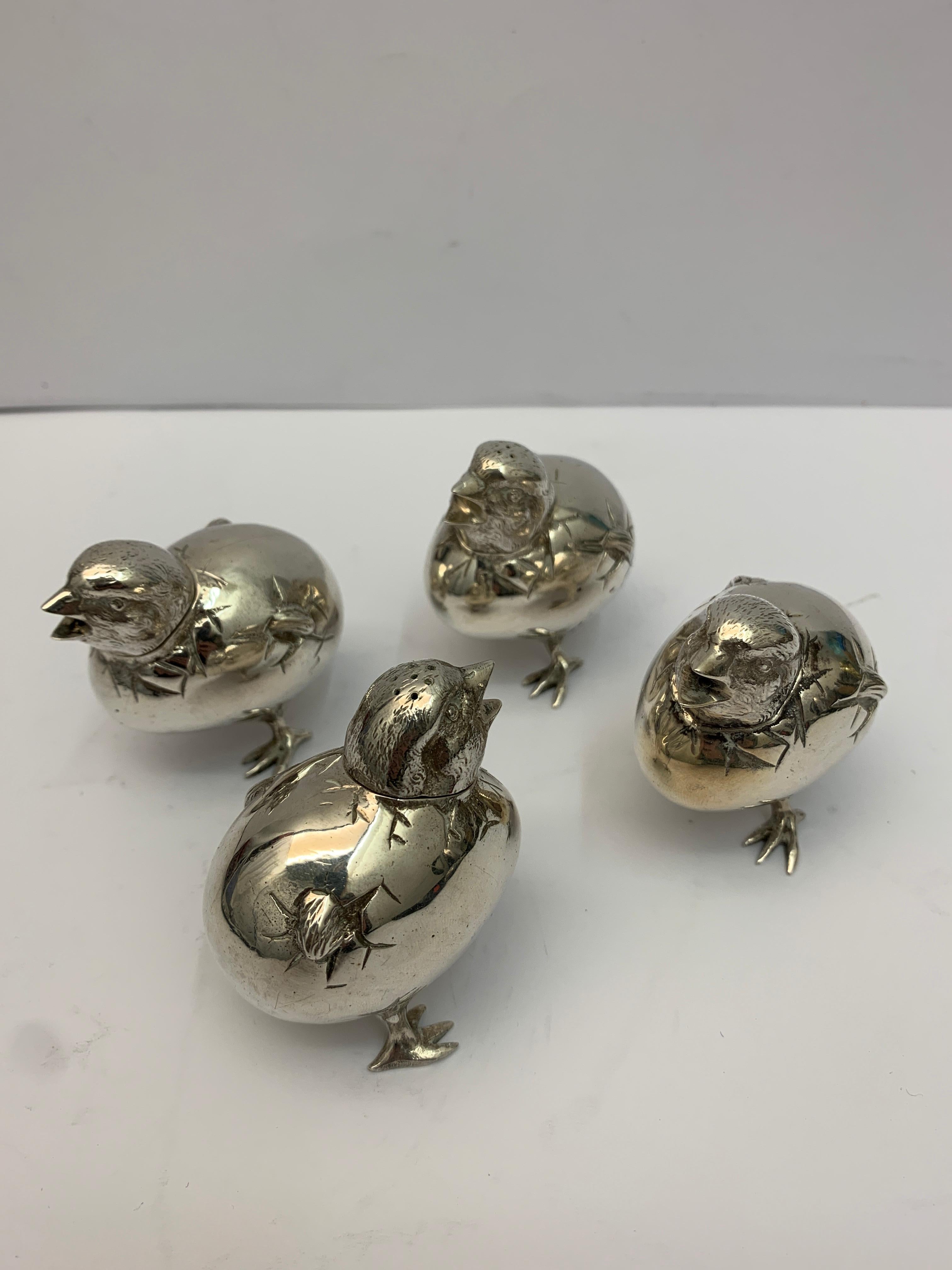 A set of four silver chick salt and peppers.