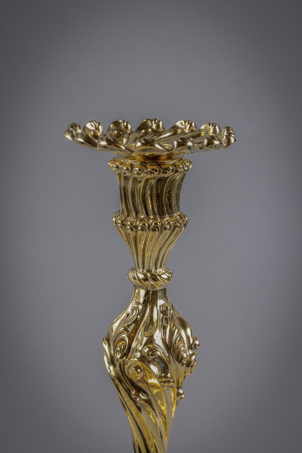 In the Rococo style, cast and chased with foliate scrolls, rising to a knopped twisting baluster stem with shaped twisting socket and removable drip-pan chased with ovolo and flutes. Marked: Howard and Co., New York, 1898.