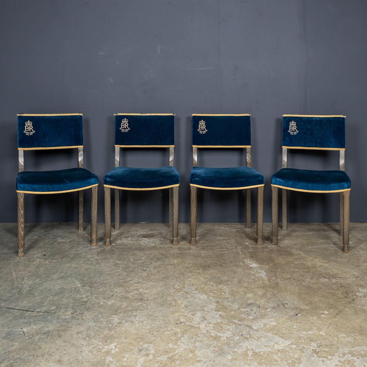 A superb 20th Century set of four vintage blue velvet chairs modelled after the chairs used by peers in Westminster Abbey during Queen Elizabeth's Coronation in 1952. Recreated for her jubilee in 1977, these chairs feature stunning blue velvet