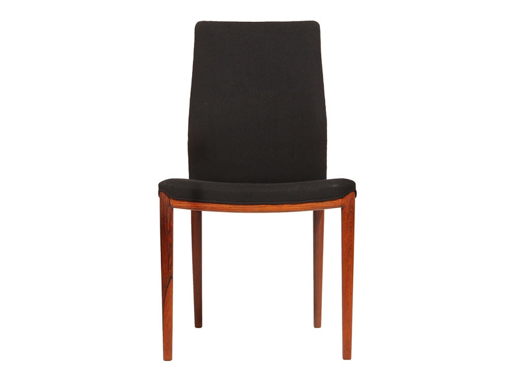 A beautiful set of four Scandinavian Modern dining chairs designed by Helge Vestergaard Jensen. Each chair is rosewood framed and upholstered in black wool. Made in Denmark, circa 1950s. 

Helge Vestergaard Jensen was a Danish furniture designer