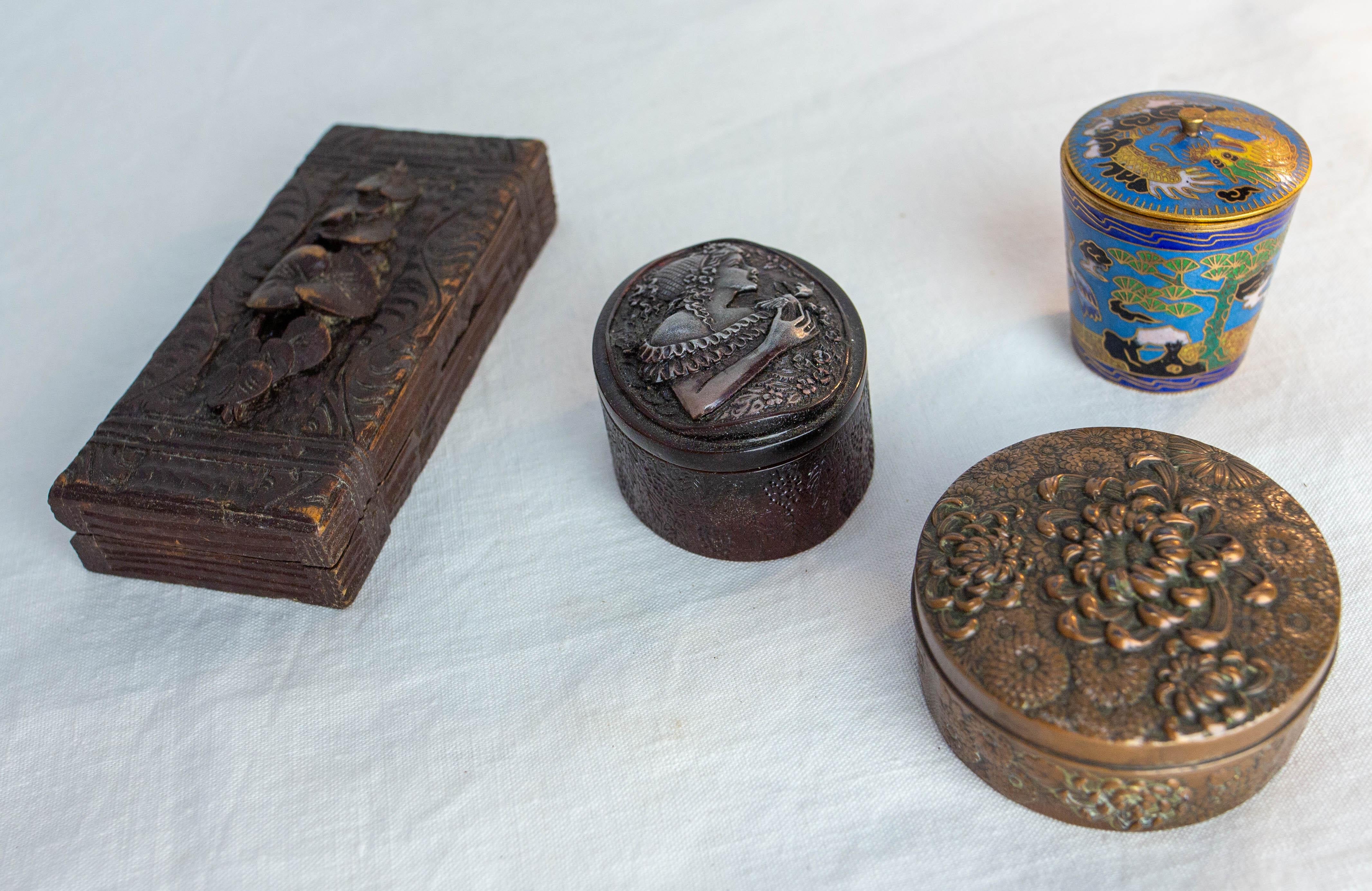 Set of four little boxes
Chinese enameled box Diameter 1.78 Height: 1.67 in. (D 5 H 4.5 cm)
Bakelite oval box with a carved woman on the top D 1.78 W: 2.36 H 1.57 in. (D 5 W: 6 H: 4 cm)
Round brass box embossed, dalhia decoration Diam : 2.36 H: 1.18