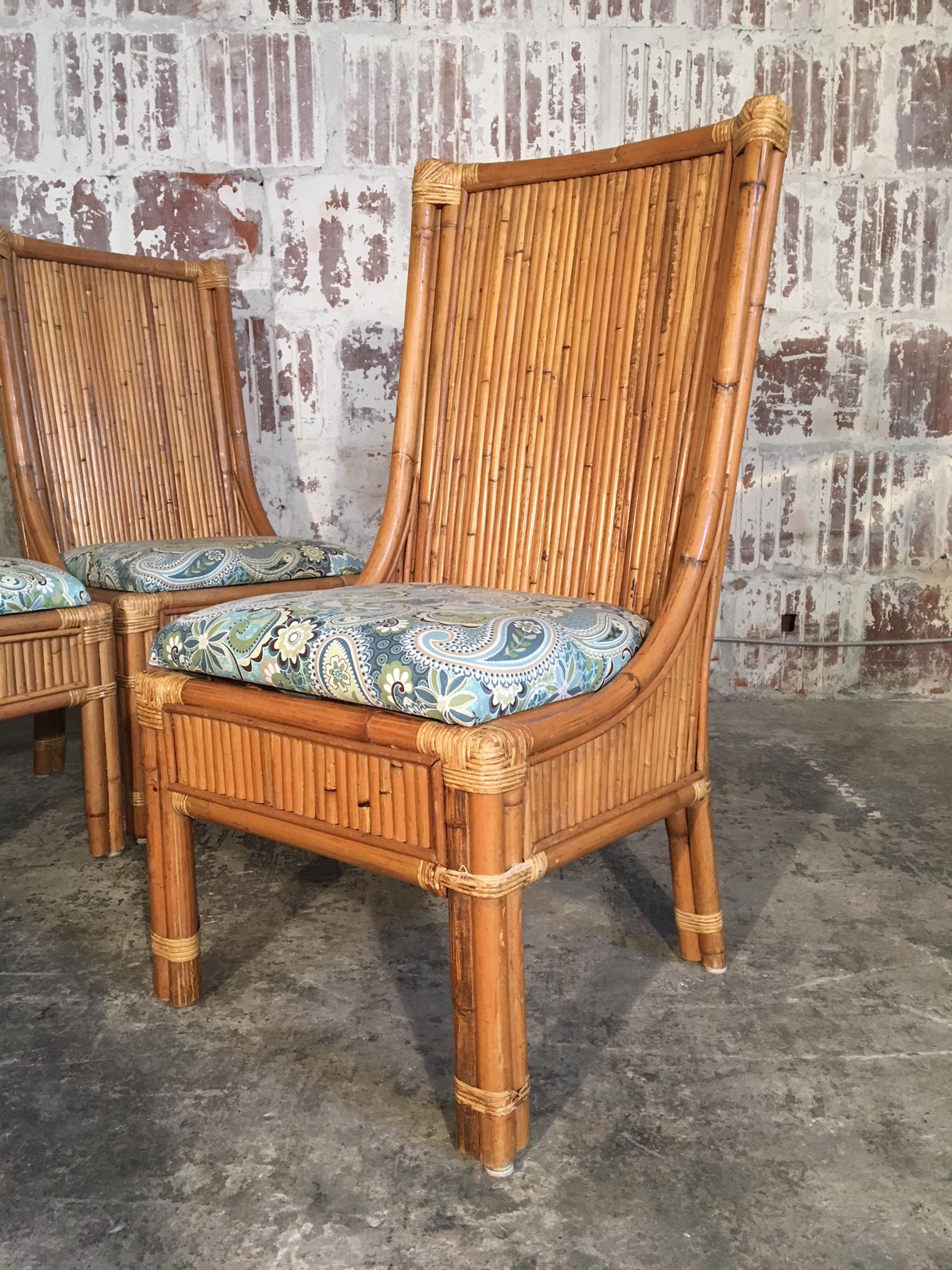 Set of 4 high back split pencil reed rattan dining chairs add a tropical touch to any decor. Very good vintage condition with minor signs of age appropriate wear. Structurally sound. Professional reupholstery available.