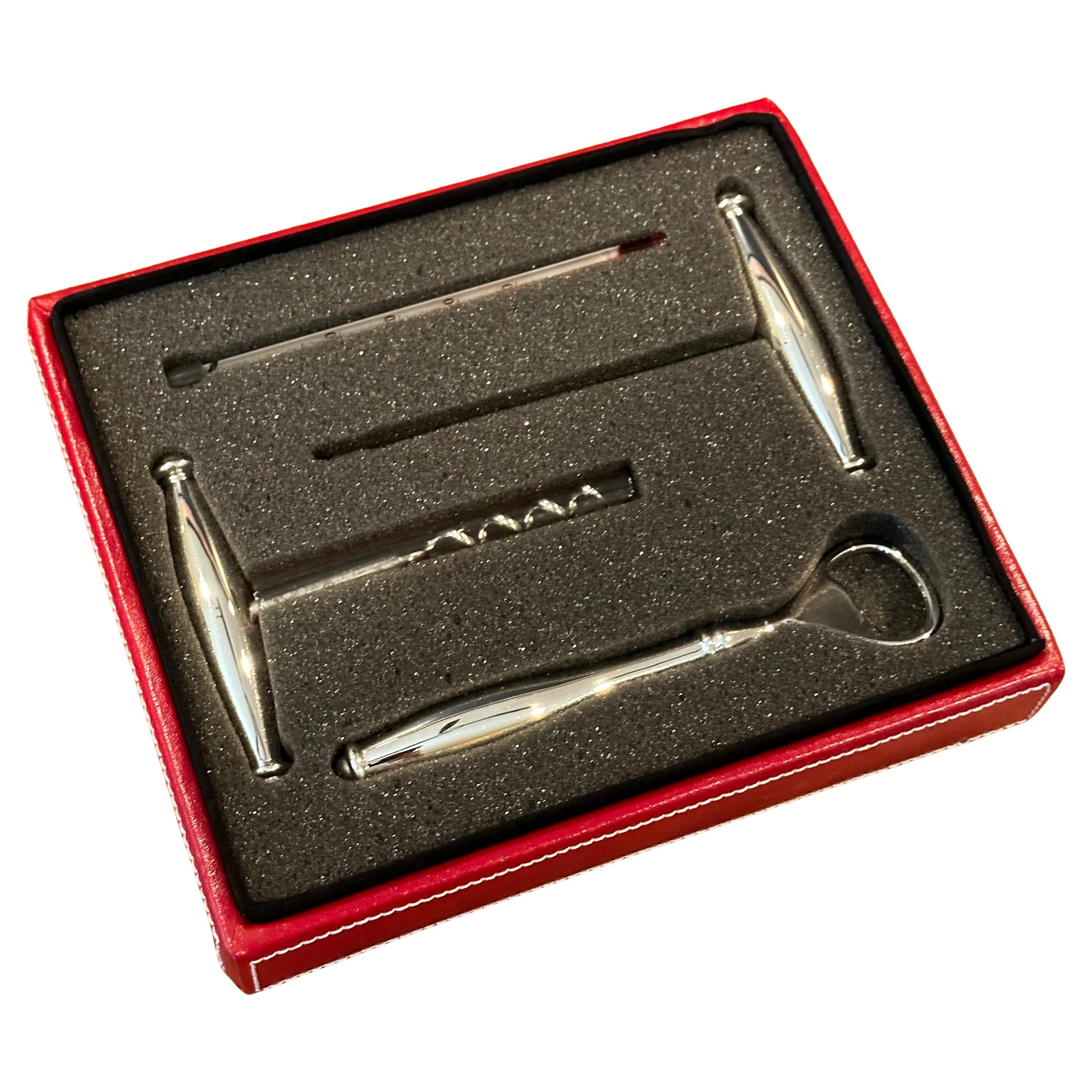 Satz von vier Bar-/Weinwerkzeugen aus rostfreiem Stahl in rotem Lederetui von Wolf Designs, ca. 1990er Jahre. Das Set ist unbenutzt und neuwertig und enthält einen Flaschenöffner, einen Korkenzieher und zwei Weinthermometer aus Edelstahl.  Tolles