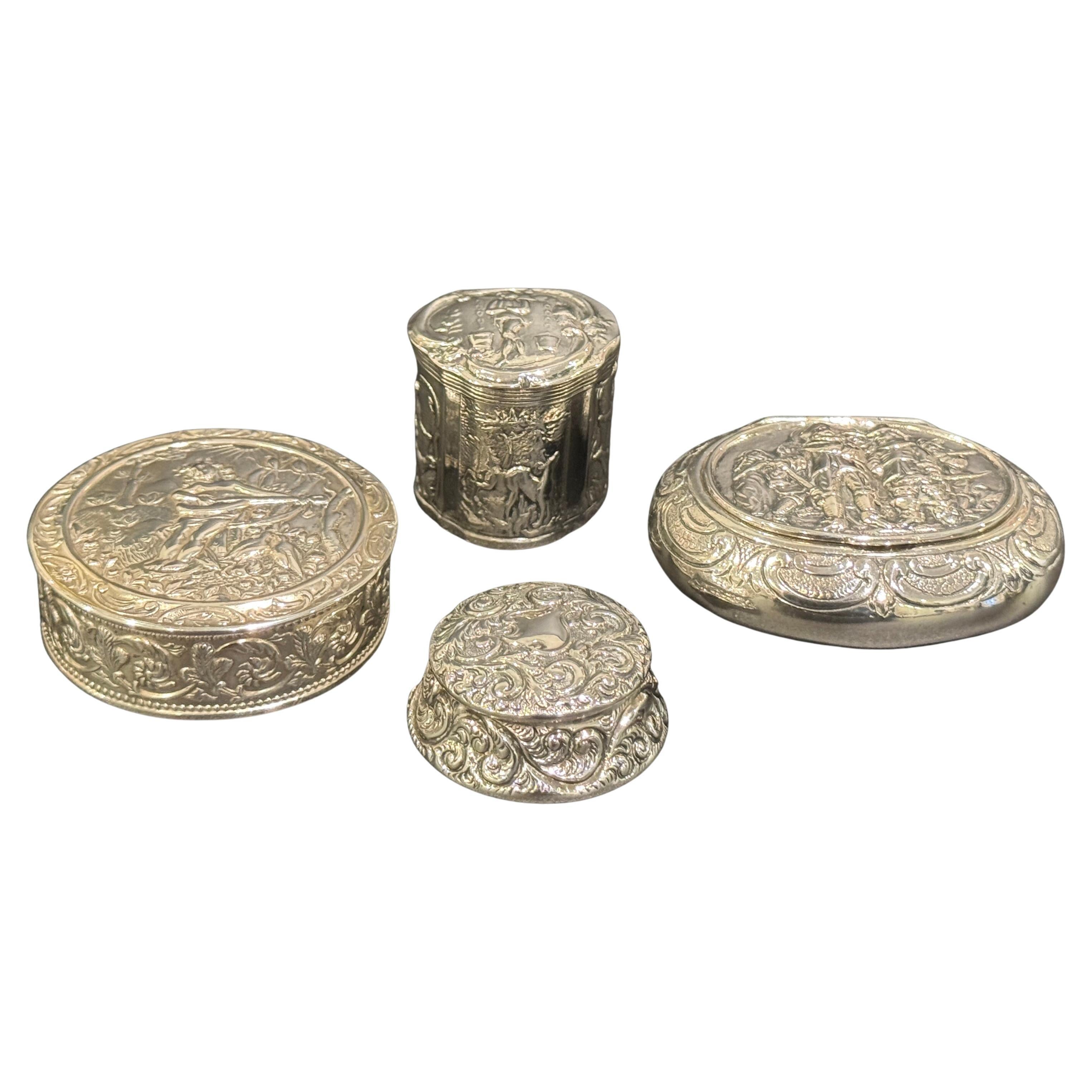 Colección de cuatro cajas decoradas con repujado de esterlina y plata
