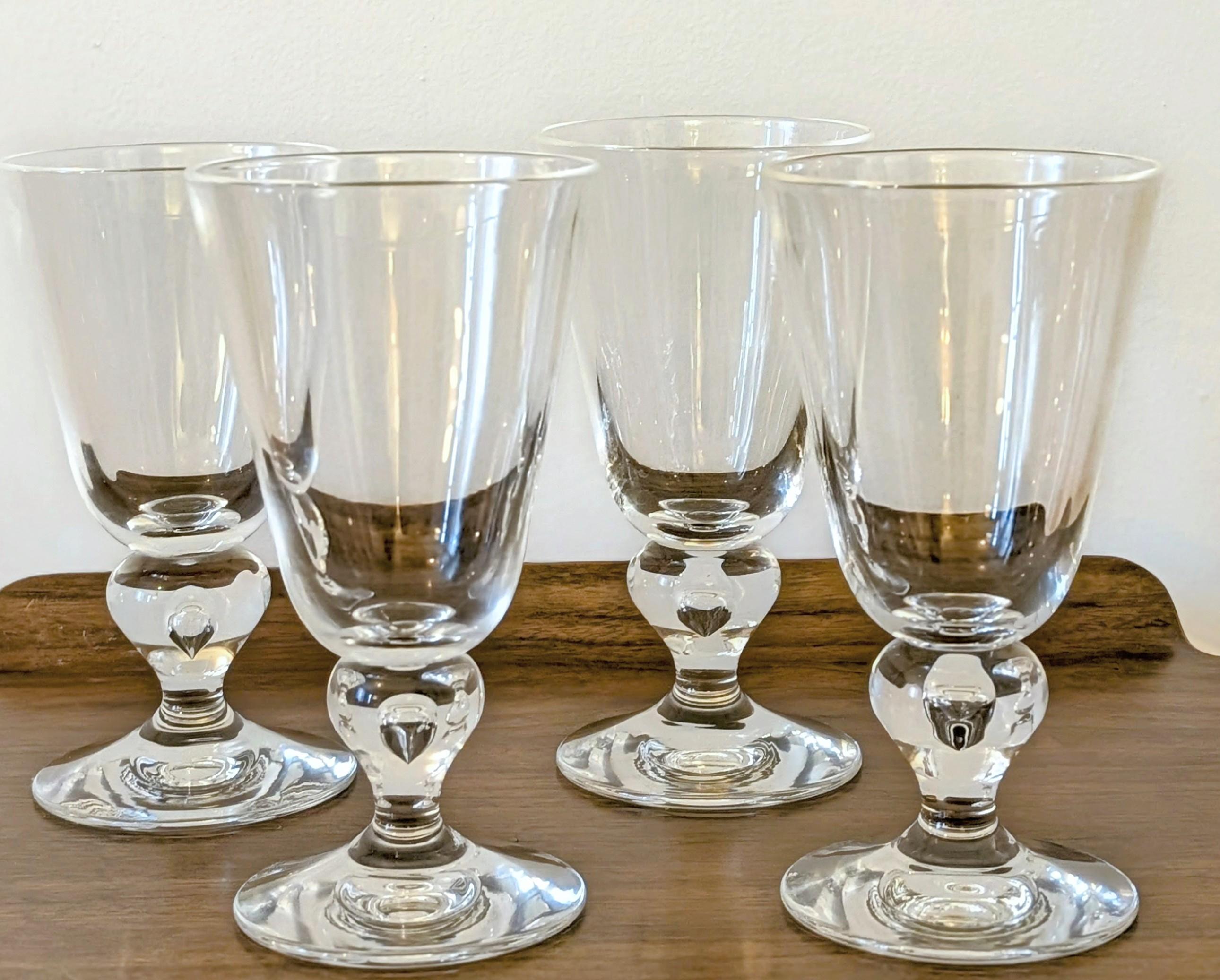 Questi eccezionali calici da acqua a balaustro Steuben #7877, realizzati intorno agli anni '40, rappresentano uno dei più celebri design di bicchieri prodotti dall'iconica vetreria americana. Soffiato a mano nel rinomato cristallo di piombo incolore