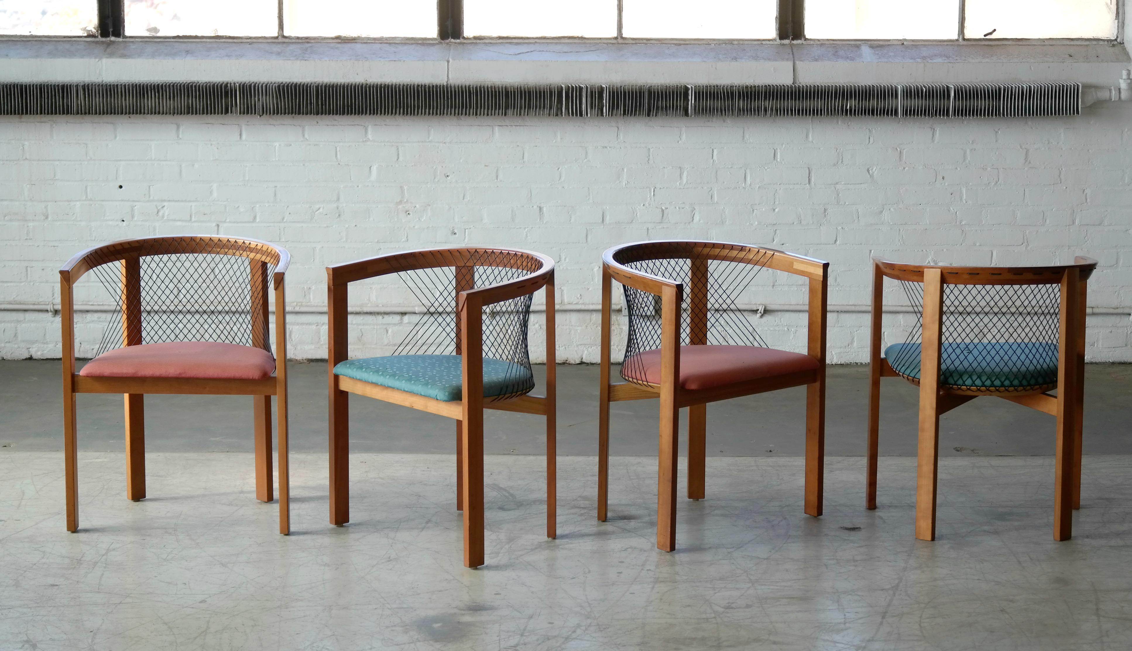 Set of four stunning sculptural string chairs designed by Niels Jørgen Haugesen for Tranekær Furniture Denmark, circa 1980. Each chair features angular wood frames in satin-finished cherrywood. The minimal, post modernist style frame is complemented