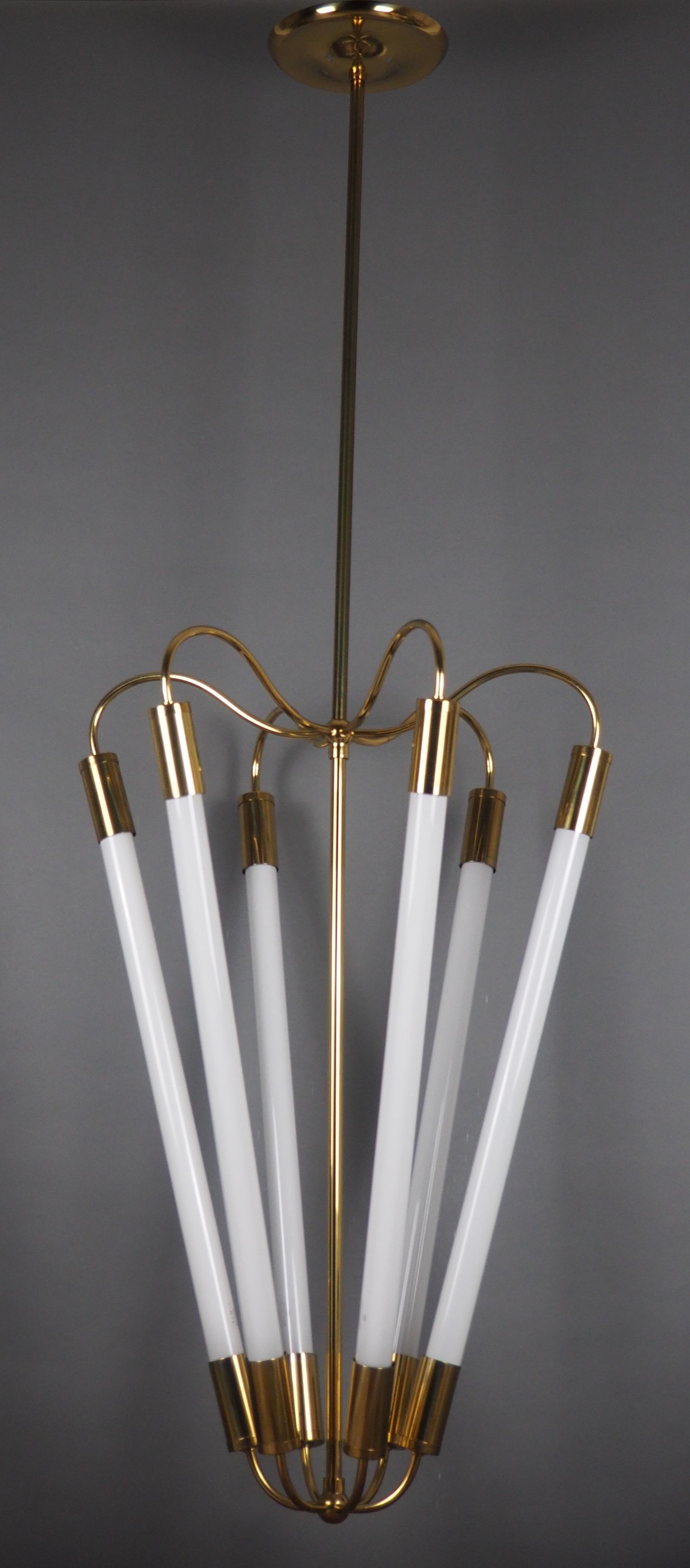 Stunning set of four Bauhaus Art Deco period polished brass chandeliers with neon tubes by Kaiser, Germany, circa 1940s.
(The height can be shorten)

The chandeliers needs each six neon L20W/ 25 tubes for illuminate and each three transorferes