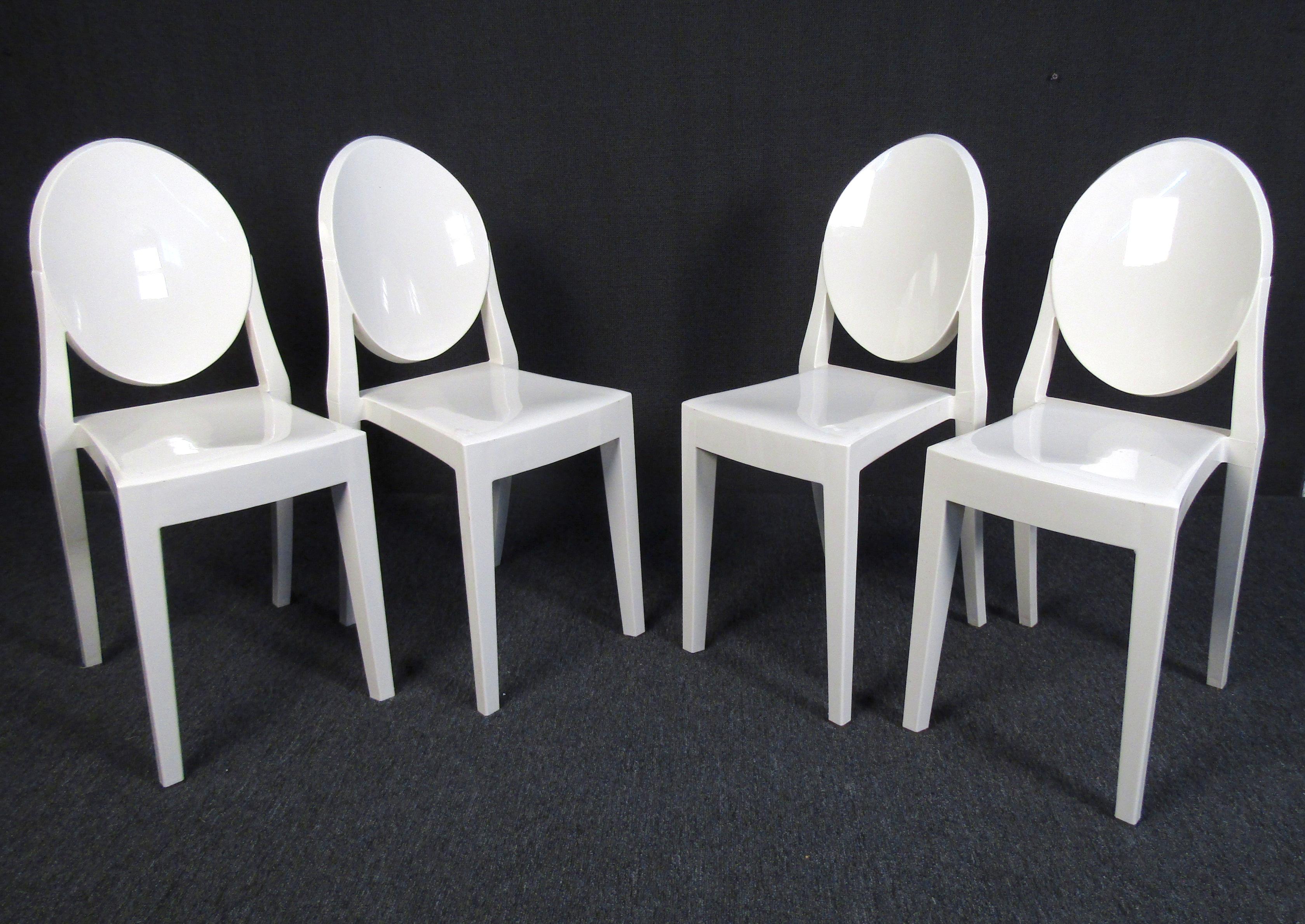This set of four Mid-Century Modern chairs feature a unique minimal design in solid white plastic. Both understated and stylish, these chairs can make a statement in any room or setting. Please confirm item location with dealer (NY or NJ).