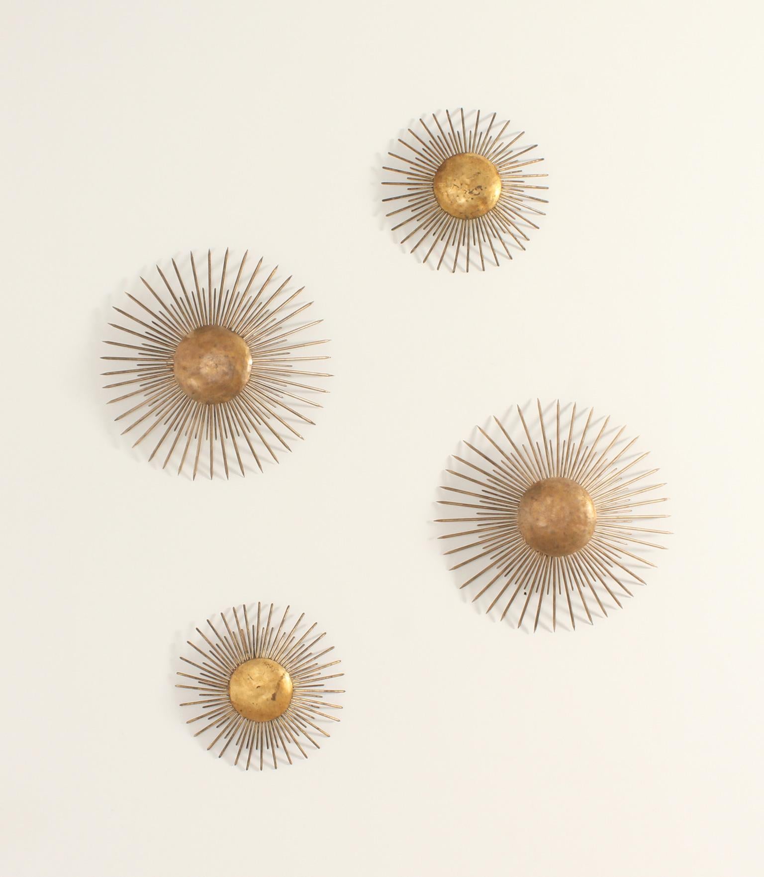 Set of four Sunburst wall or ceiling lamps from 1950's, Spain. Gilt forged iron with two bulbs and in two different sizes.

Dimensions: 36 Ø x   9 D. cm. Small
                     50 Ø x  13 D. cm. Large