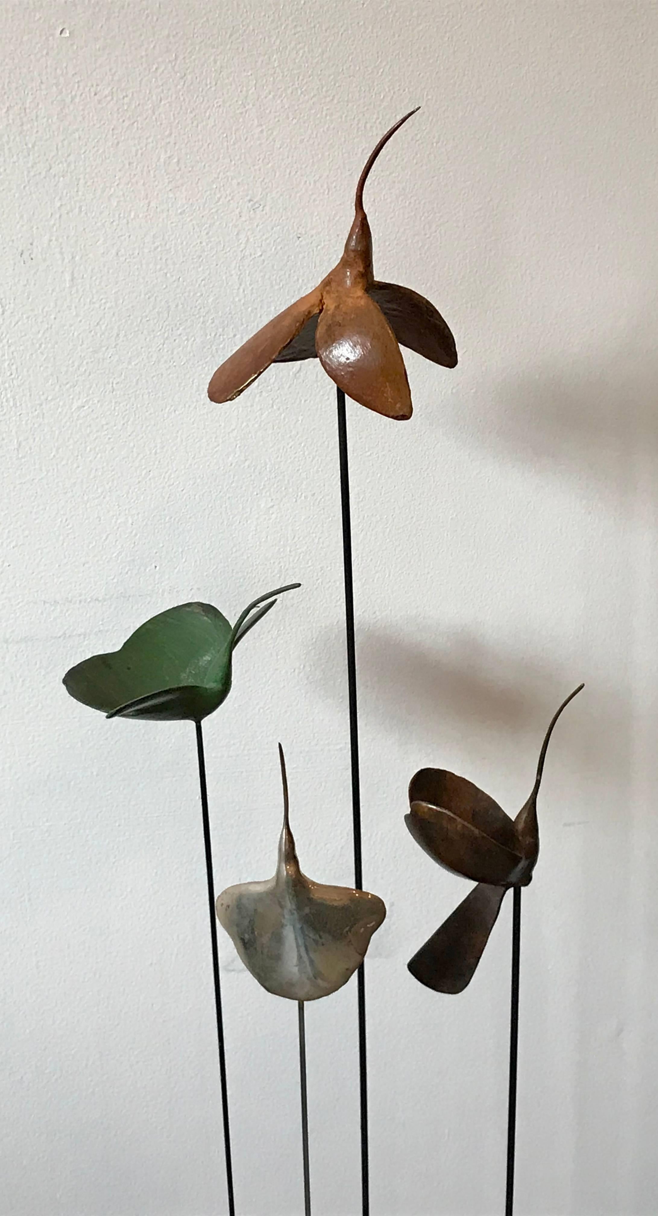 Beautiful set of four mobile suspended hummingbirds by American sculptor Sharon Wandel, three in patinated bronze and one is sterling silver. Mounted on flexible metal rods, metal cylinder base.