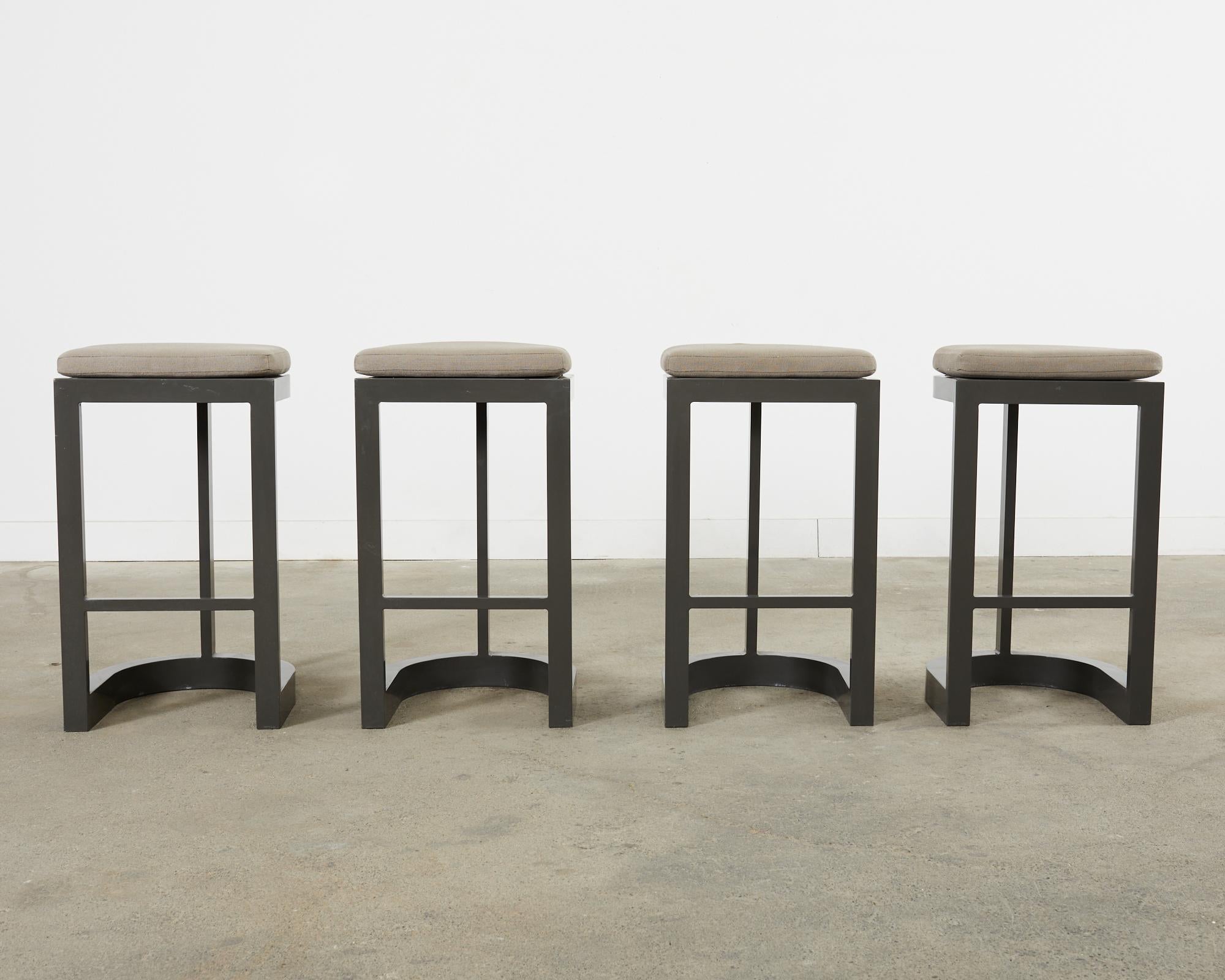 Chic set of four modern style patio and garden barstools. Designed by Terry Hunziker for Sutherland. The great lakes design barstools feature a modern flat bar design with a grey powder coated aluminum frame. The design has a round back and a