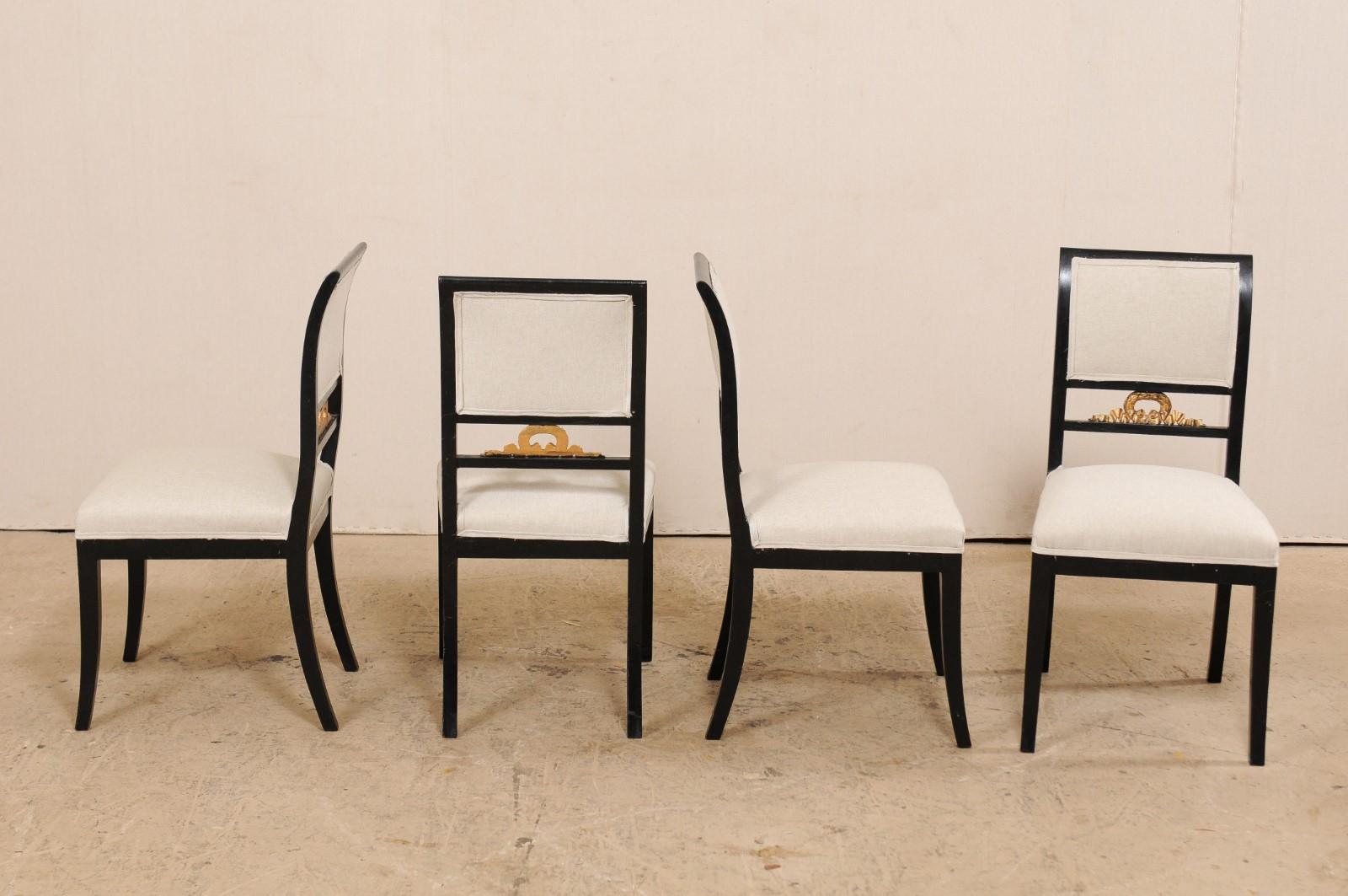 Un ensemble de quatre chaises latérales Empire suédoises du milieu du 19e siècle par le fabricant de meubles F. Pettersson. Ces chaises anciennes de Suède ont un dossier élégamment incurvé, avec des rails supérieurs droits en bois encadrant leurs