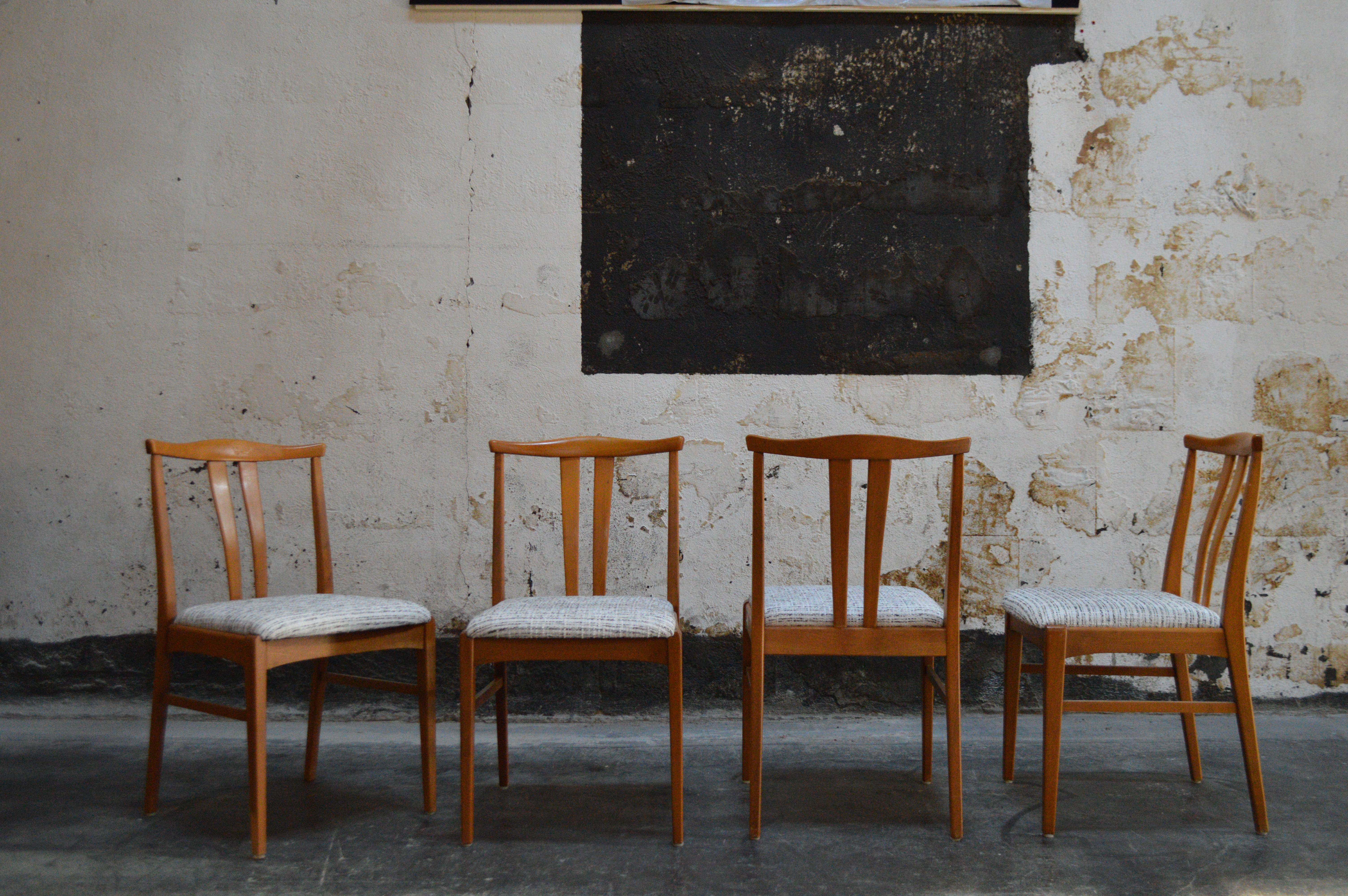 MCM set of four Swedish modern high-back dining chairs in beech. The tall ergonomic backs slightly bow and lend to hours of comfortable dining for those long dinner parties and holidays. Newly padded and upholstered seats in a mingled chenille tweed