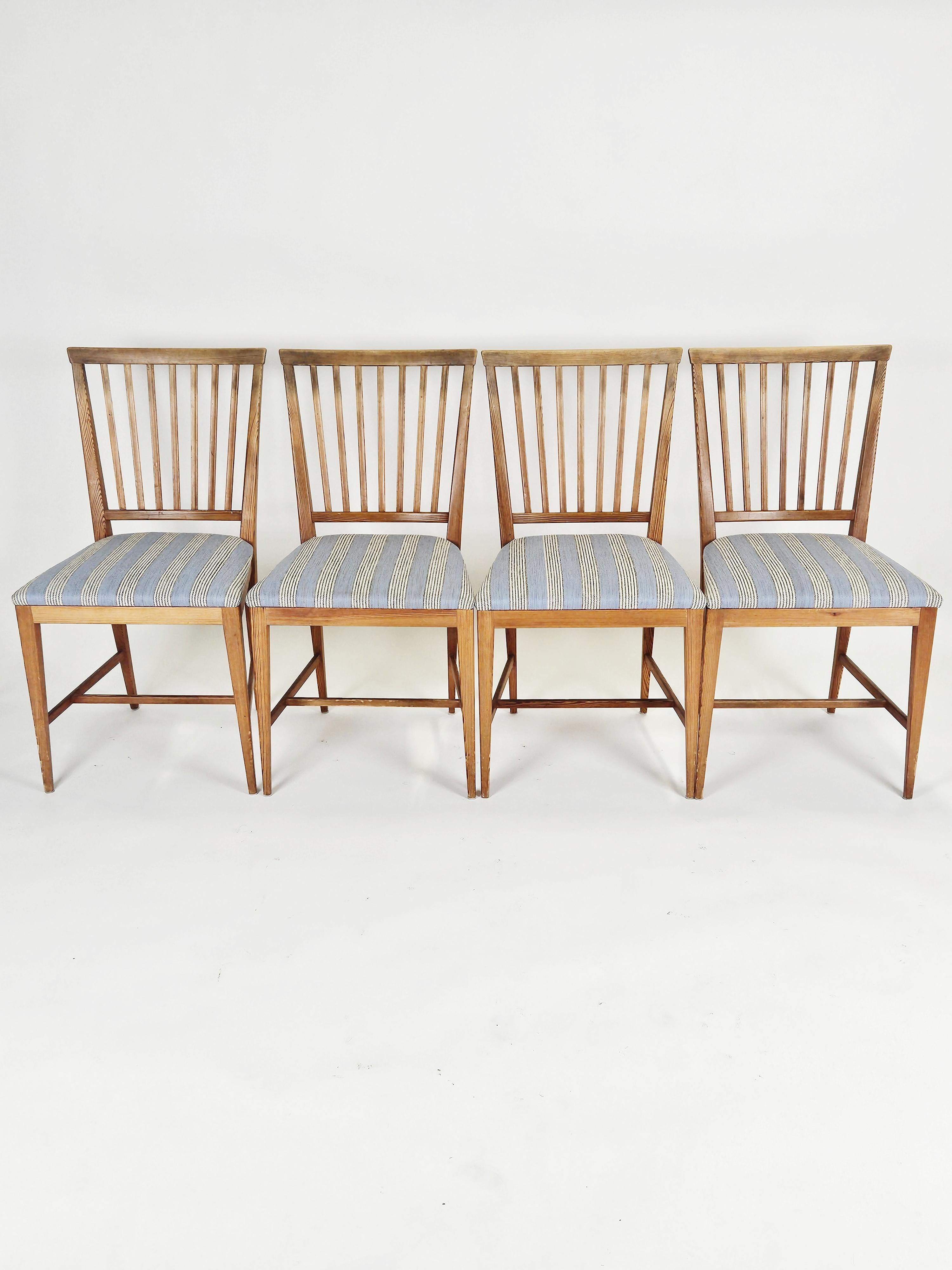 Set of four  Scandinavian modern pine dining chairs designed by Carl Malmsten during the 1960s. 

Fits together perfectly with other sports cabin furniture from Sweden. 

Beautiful original fabric in blue, grey and white. 

Lovely patina. 