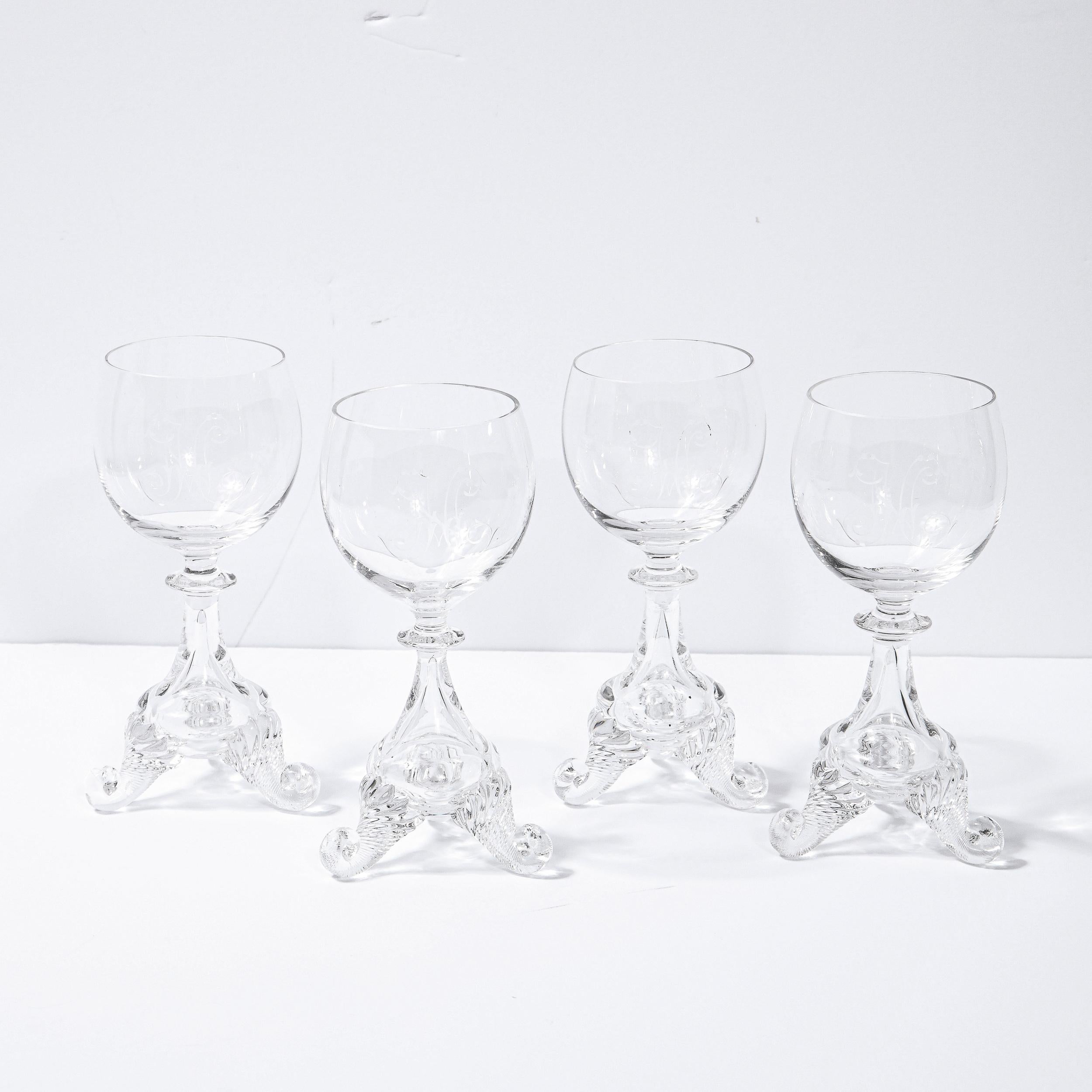 This stunning set of four liqueur glasses were realized in Sweden during the 19th Century. Each glass features sculptural striated curled feet that ascend into an amorphic volumetric gourd shaped body that tapers into a cylindrical neck with a