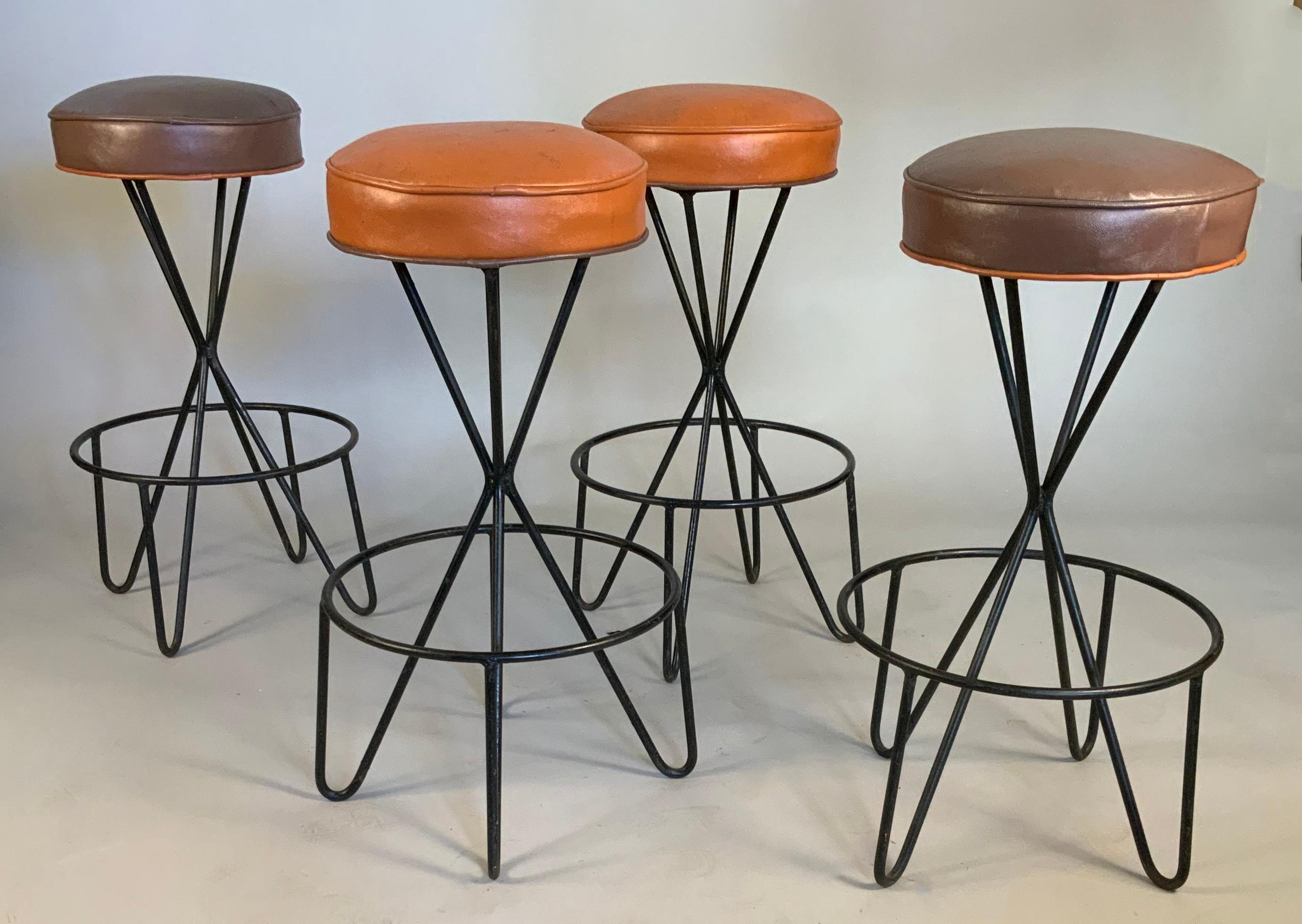 A beautiful set of four vintage 1950's Iron base swivel barstools by Paul Tuttle. very nice design with the iron frame gathered in the center of the base, and an iron ring footrest as well. the thick padded seats are in their original vinyl, two