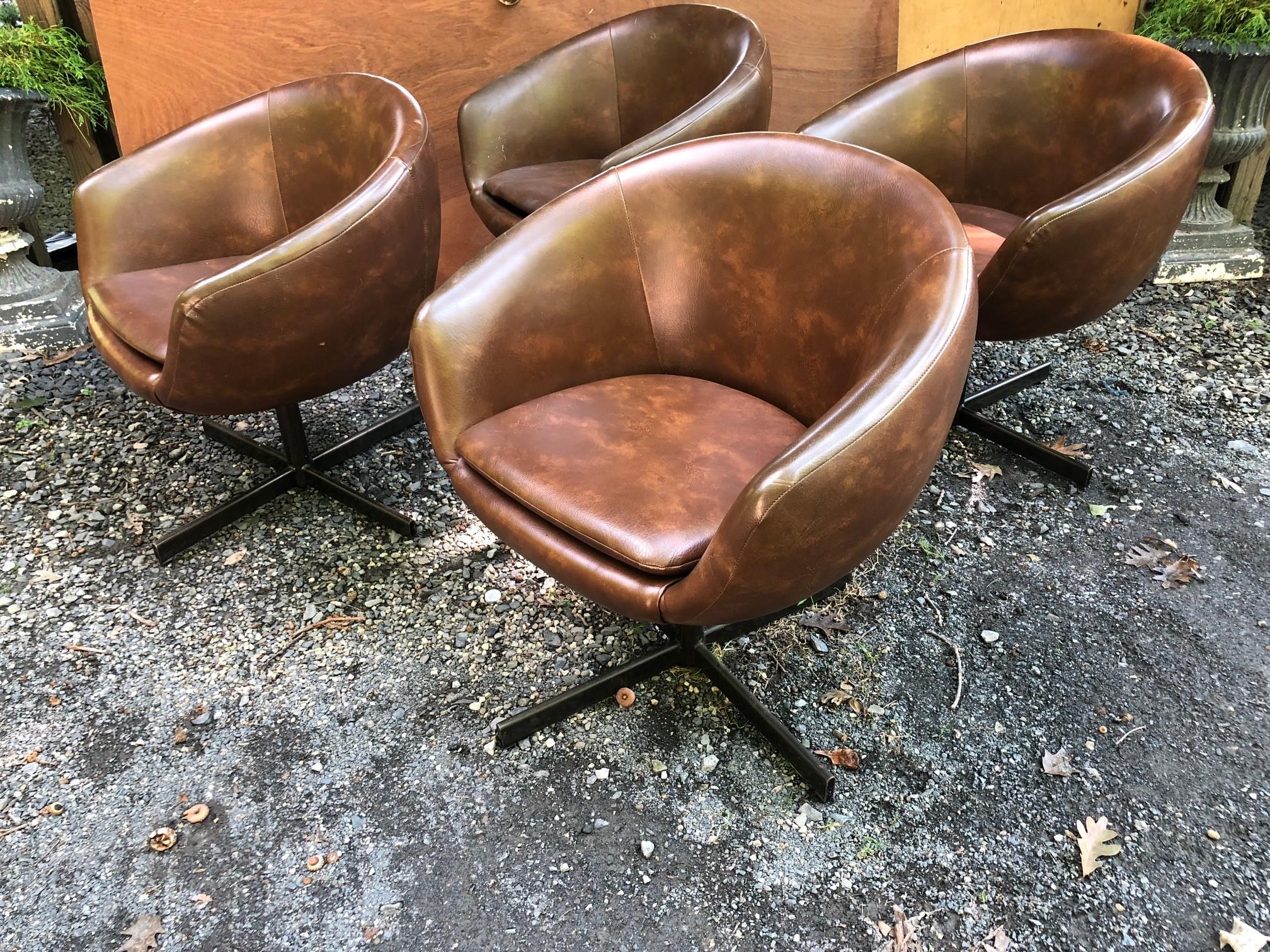 Set of four swivel tub chairs by Shelby Williams for The Playboy Club. Upholstered in a mottled brown vinyl.