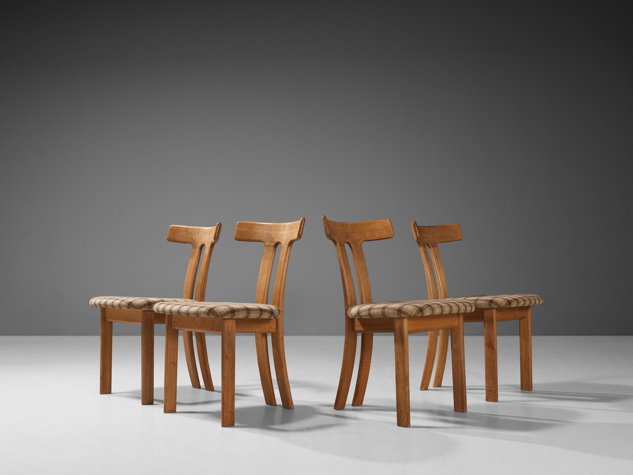 Set of four dining chairs, oak, fabric, France, 1960s. 

These dining chairs have a strong resemblance to Carl Hansen's t-chair and the dining chairs by Sapporo for Mobil Girgi, yet this design is different in its details. Strong vertical and