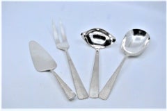 Set of four table cutlery in hammered silver handles
