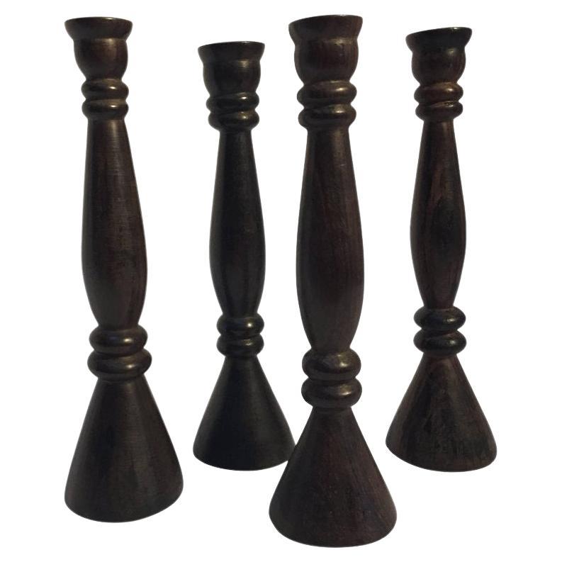 Ensemble de quatre grands bougeoirs en bois sculptés à la main en vente