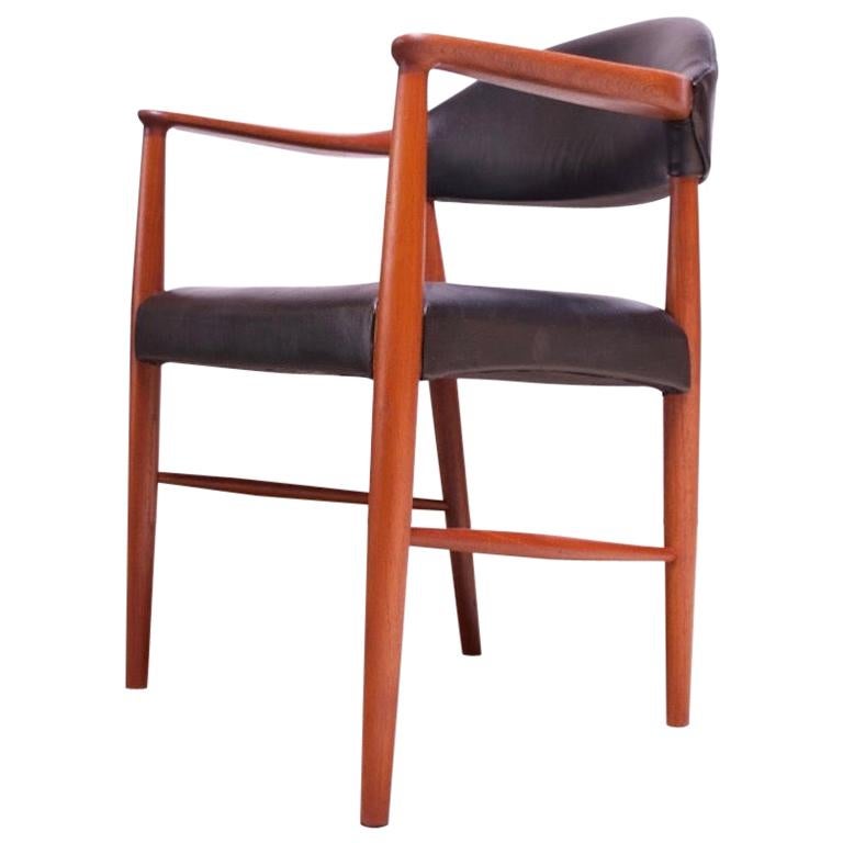 Set of four model 223 armchairs by Kurt Olsen for Slagelse Møbelværk (1950s, Denmark). Ideal for desk, dining, or occasional use. Black leather is original and shows good age / patina (cracking and wear in places, as shown). The teak has been newly