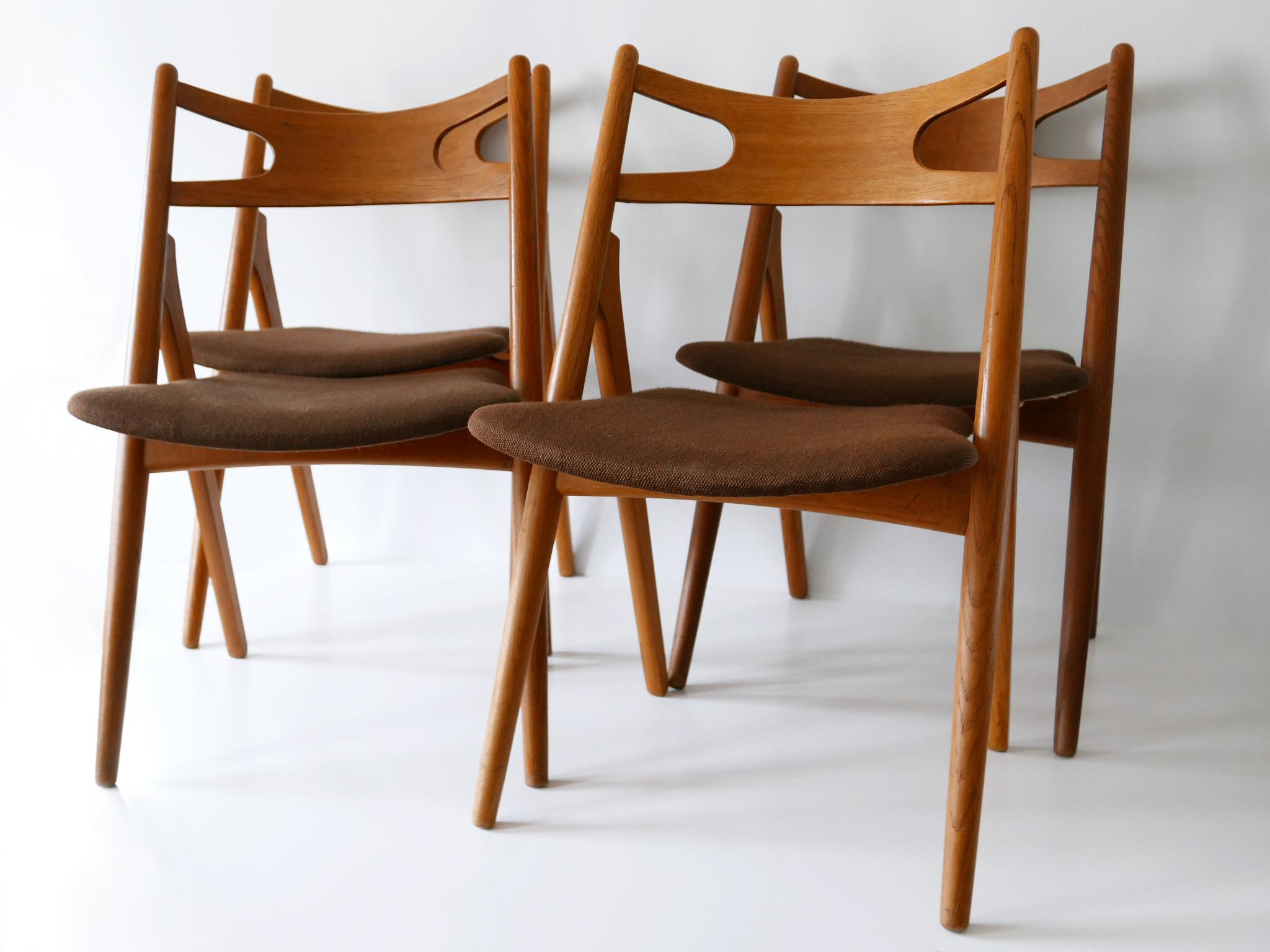 Original, elegant and minimalistic set of four danish modern CH-29 Sawbuck dining chairs. Designed by Hans J. Wagner in 1951 for Carl Hansen & Søn, Denmark. Manufactured probably in 1960s. Manufacturer's label to underside of the seats. 

PS: 1 x